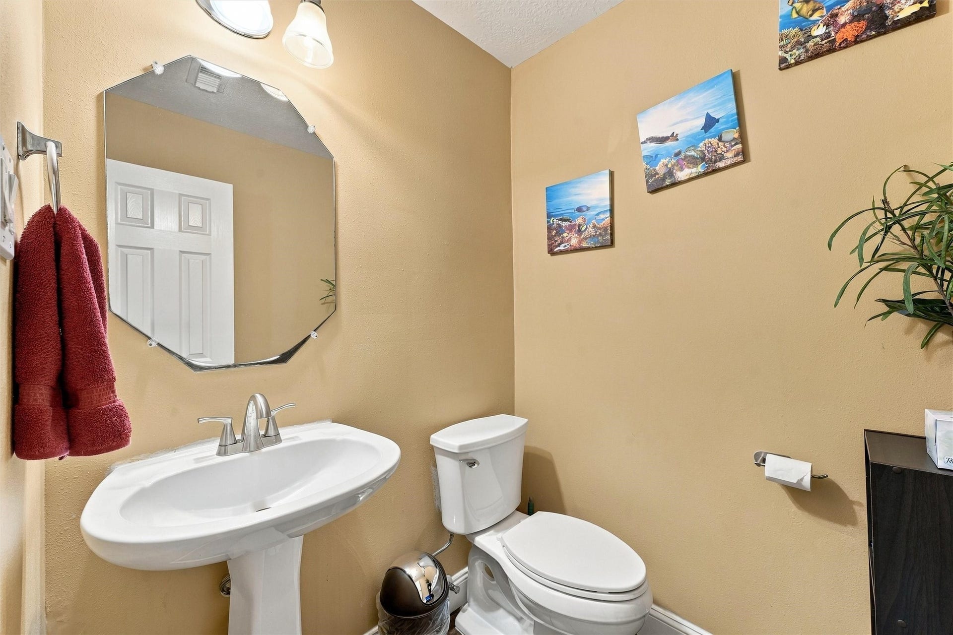 18931 Bonners Park Circle, Katy, TX 77449 Charming bathroom features a pedestal sink, modern fixtures, and tasteful decor with warm-toned walls.