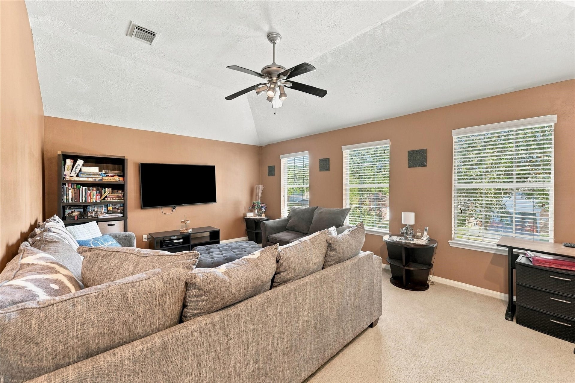 18931 Bonners Park Circle, Katy, TX 77449 Inviting game room with vaulted ceilings, and abundant natural light from large windows. Cozy seating area perfect for relaxation and entertainment.