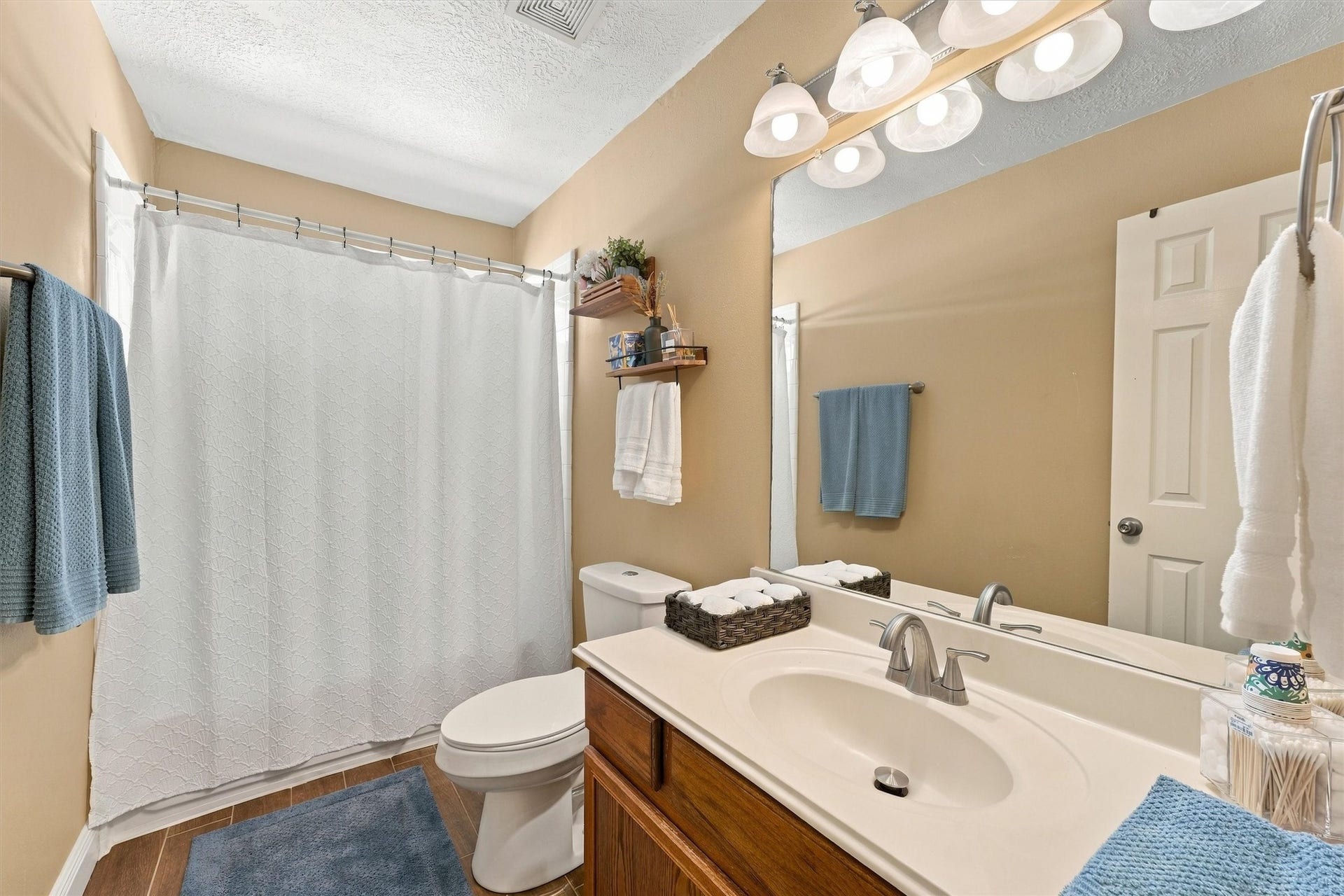 18931 Bonners Park Circle, Katy, TX 77449 Bright and inviting bathroom featuring a large mirror, elegant lighting, and a spacious vanity with ample storage.