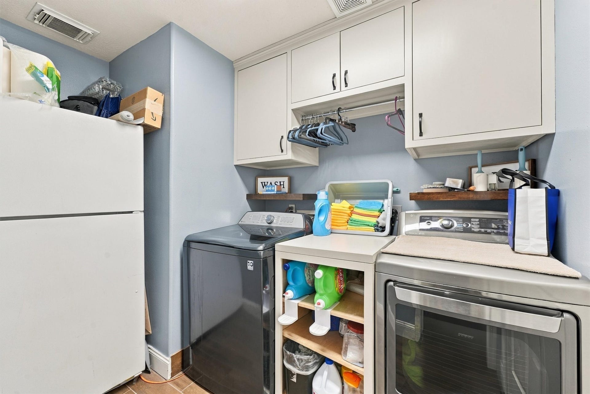 18931 Bonners Park Circle, Katy, TX 77449 Efficient laundry room featuring modern appliances, ample cabinetry, and convenient shelving for organized storage.
