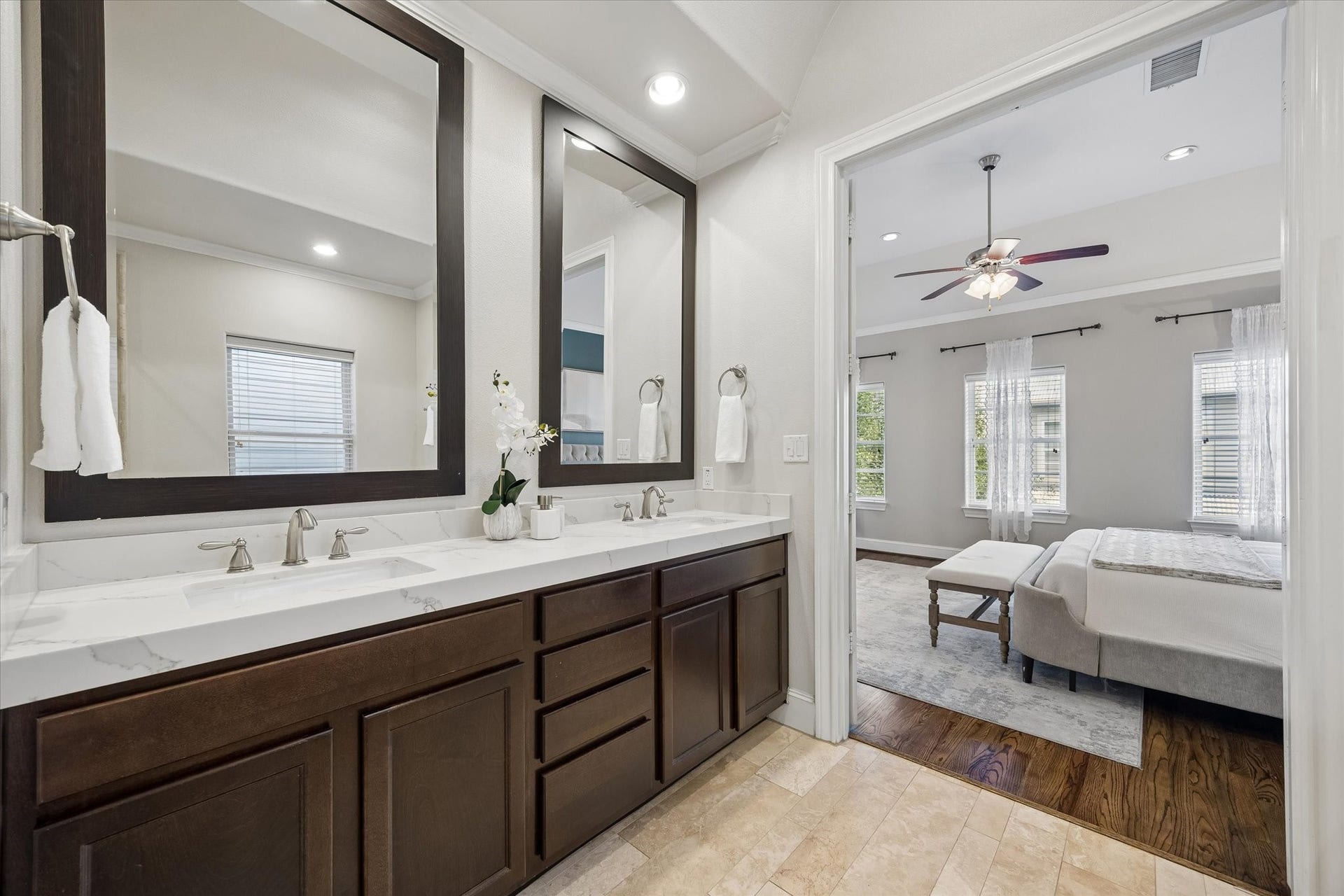 8805 Kolbe Bend Lane, Houston, TX 77080 Primary bath features a long dual-sink vanity with updated countertops, generous cabinetry, framed mirrors, and recessed lighting.