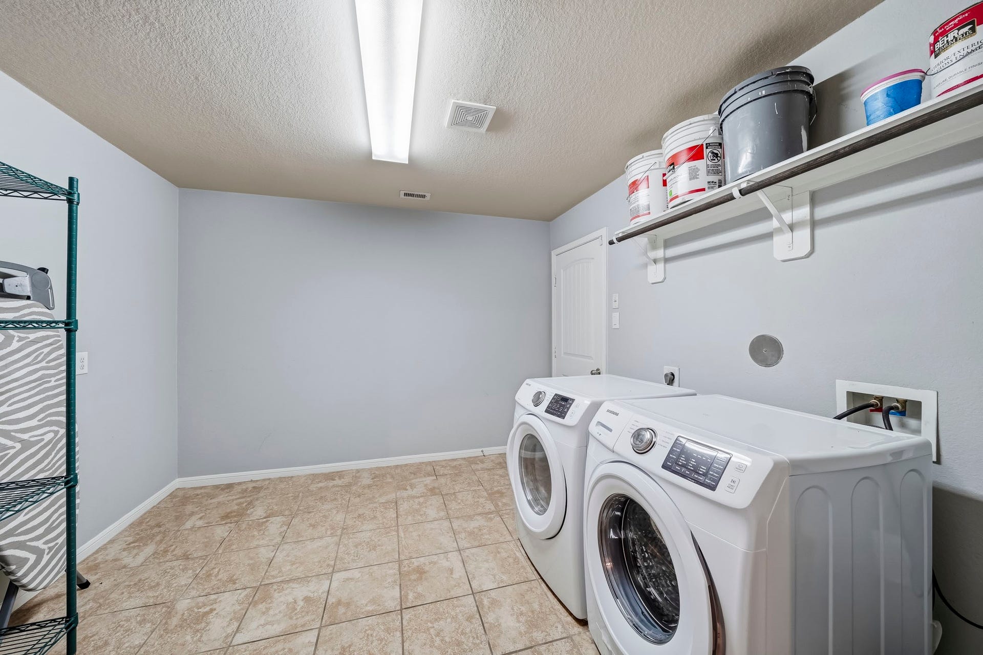 17822 Royal Breccia Lane, Richmond, TX 77407 An oversized utility room offers generous floor space, built-in shelving, and a practical layout that makes everyday household tasks easy.
