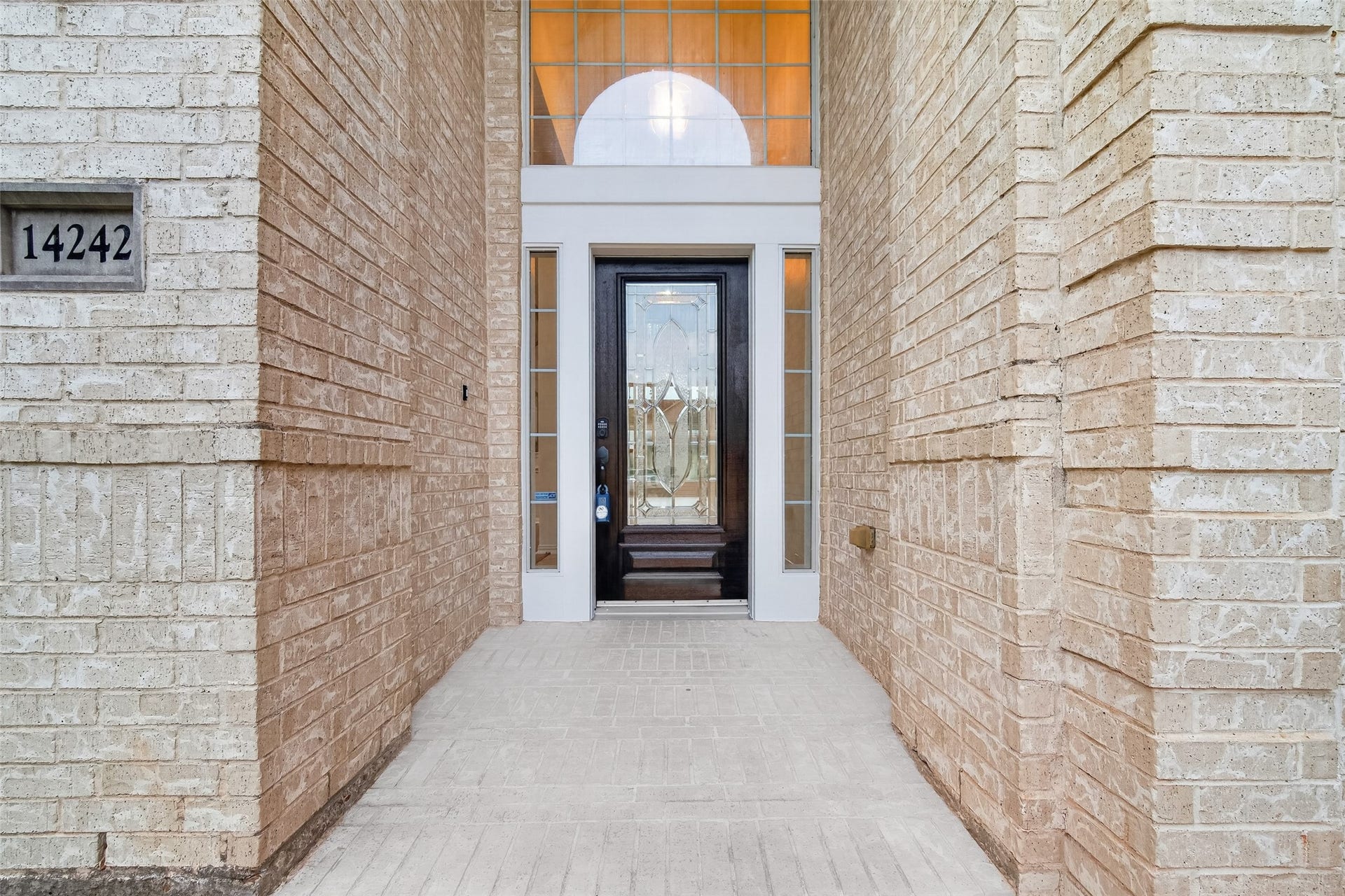 14242 Ashmore Reef Court, Sugar Land, TX 77498 Elegant glass and wood entry door creating a grand first impression, beautifully blending timeless craftsmanship with sophisticated architectural appeal