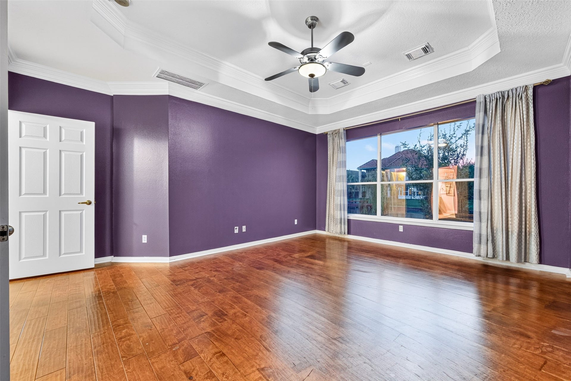 14242 Ashmore Reef Court, Sugar Land, TX 77498 Spacious first-floor primary bedroom featuring elegant tray ceilings and expansive windows that fill the room with abundant natural light, creating a bright, serene, and luxurious retreat