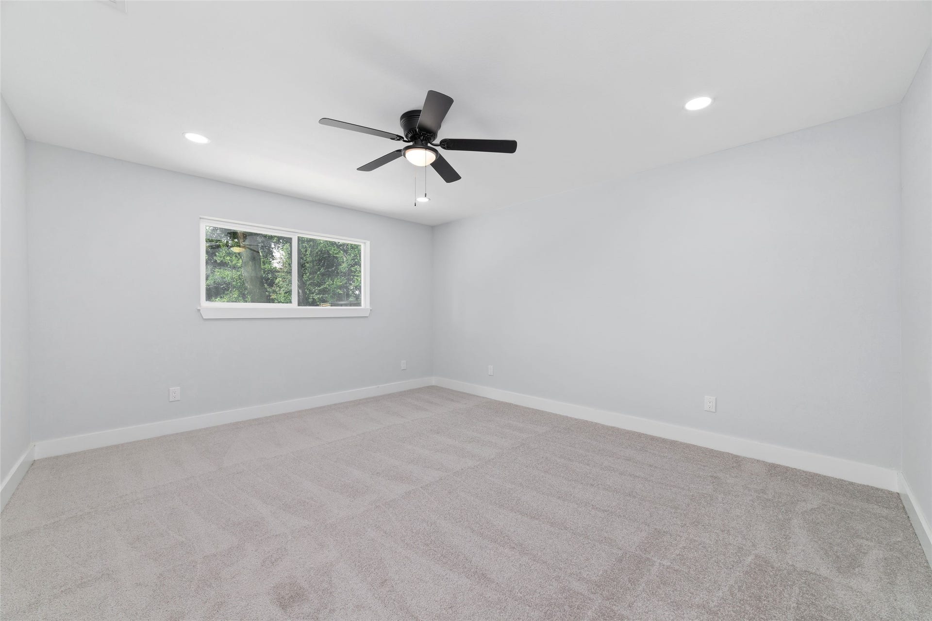 The primary bedroom features neutral tones, carpet flooring, recessed lighting, and a ceiling fan, with an adjoining bathroom.