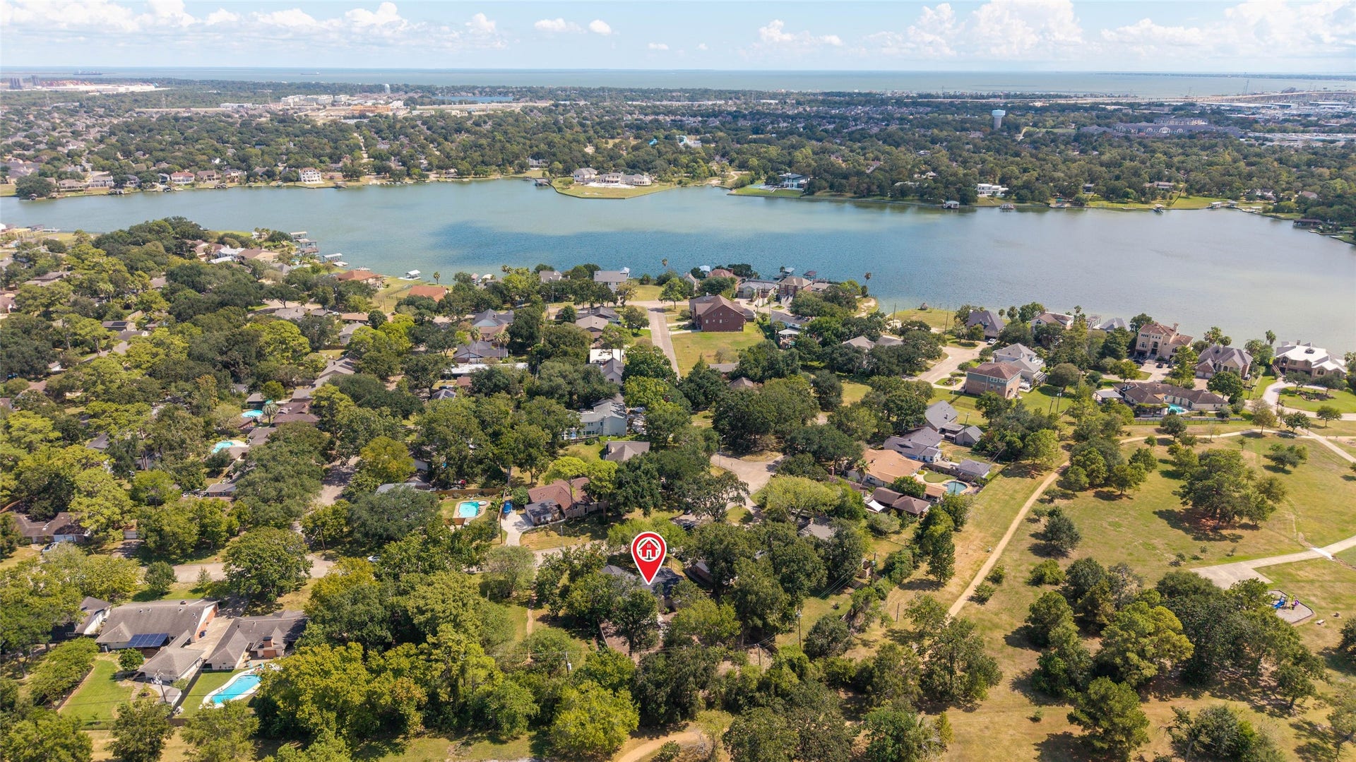 Aerial perspective highlighting the homes location within Timber Cove, surrounded by mature trees and nearby Taylor Lake.