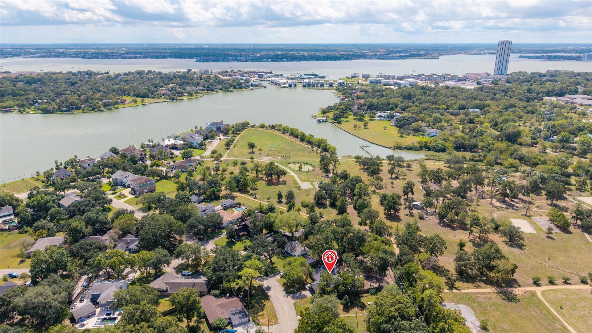 A broader aerial perspective captures the lake, winding shoreline, and surrounding neighborhoods, offering a look at the area beyond the property.