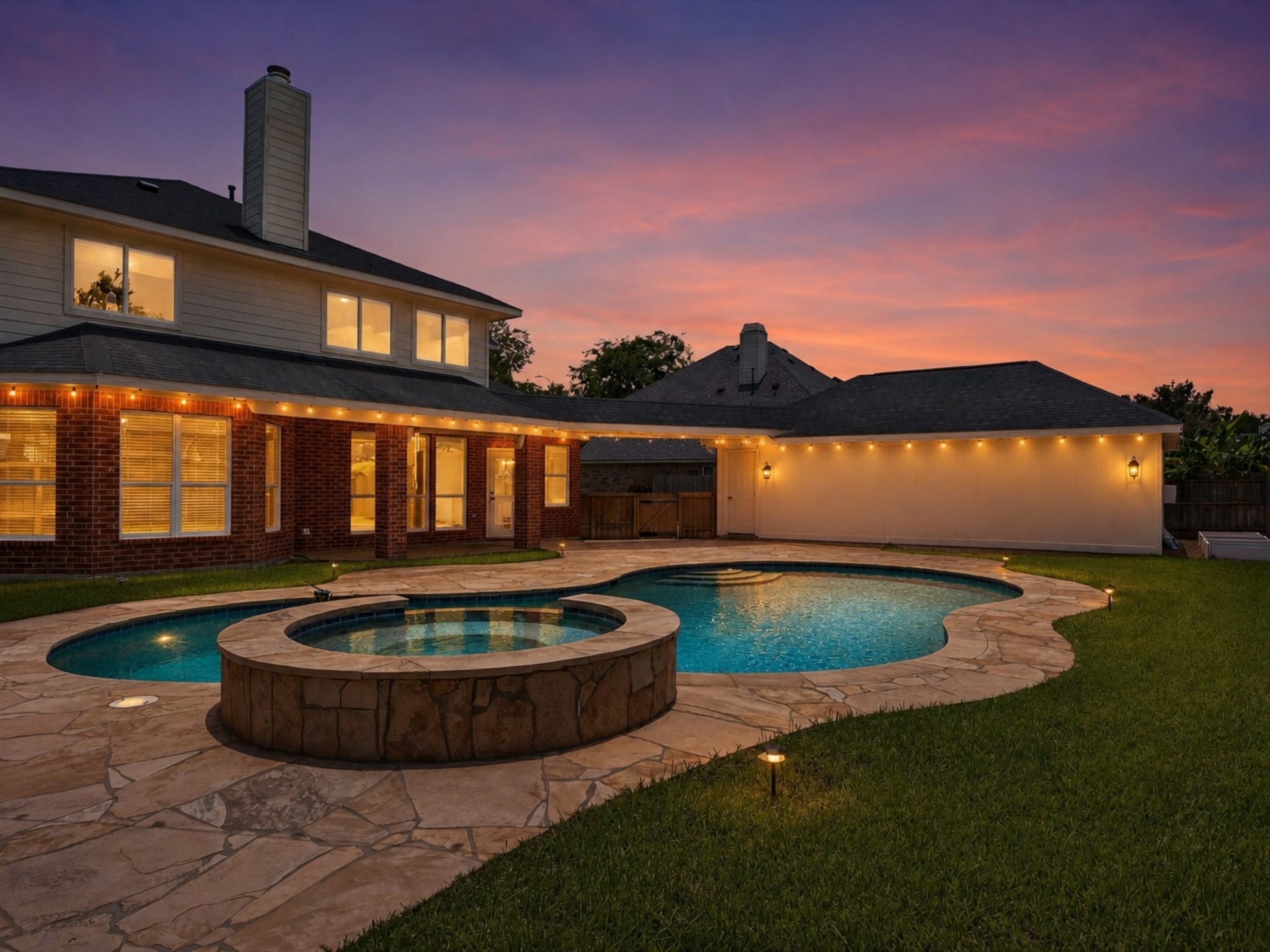 Spacious backyard with a pool, spa, lush lawn, and detached garage.