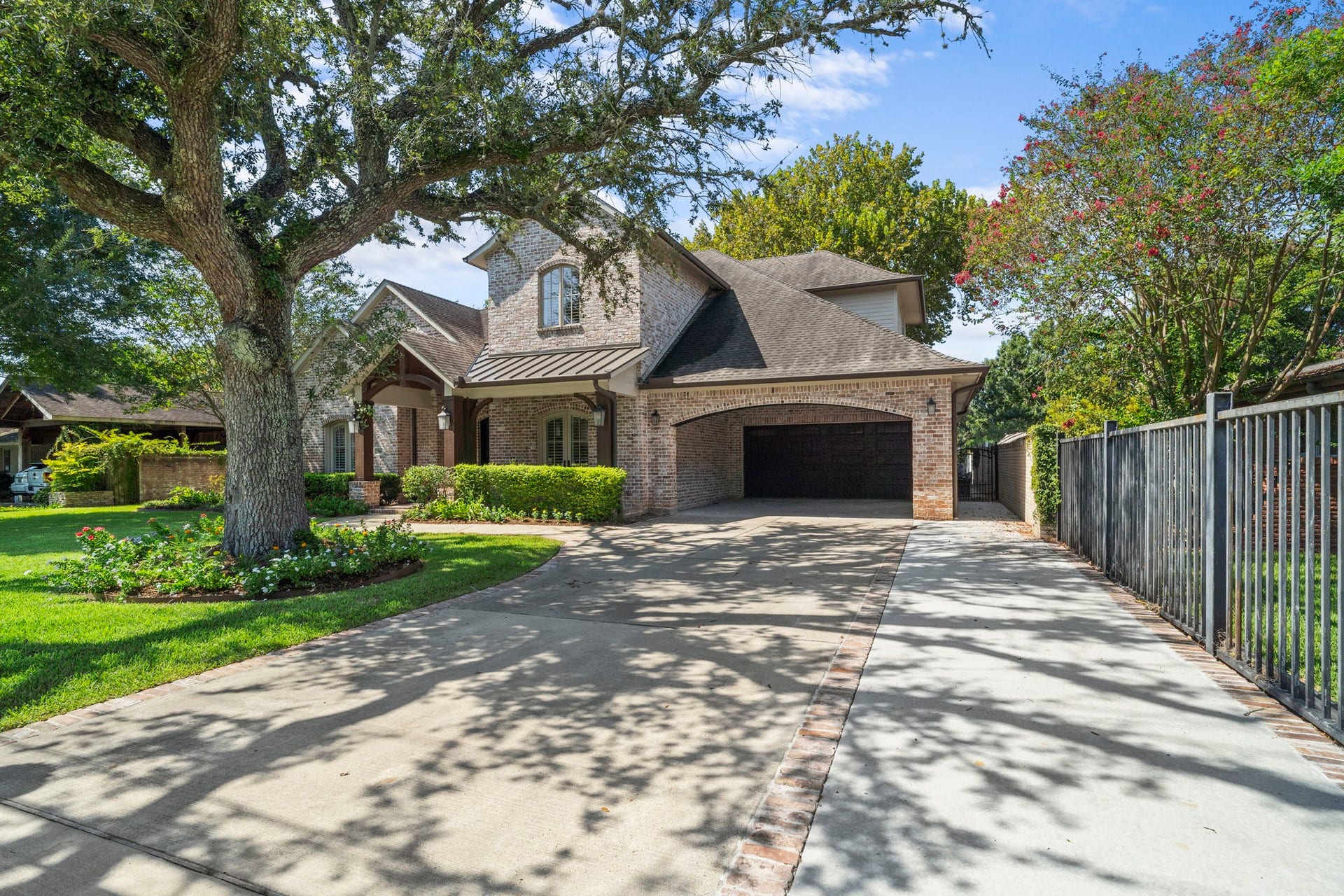 706 Oyster Creek Drive, Sugar Land, TX 77478 A long, triple-wide driveway leads to the two-car porte-cochre and attached two-car garage, offering ample off-street parking for family and guests.