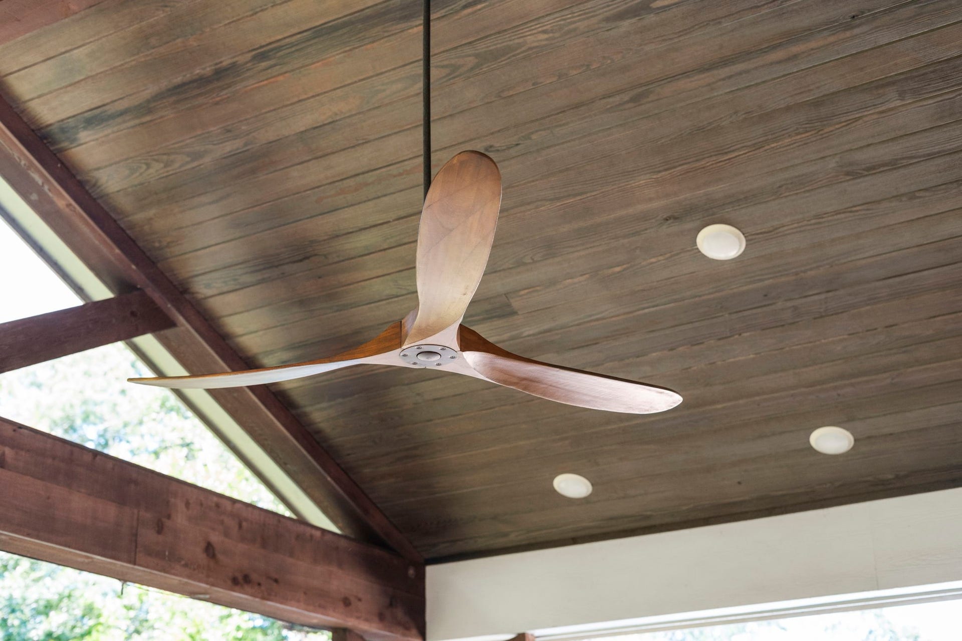 706 Oyster Creek Drive, Sugar Land, TX 77478 A vaulted wood ceiling with recessed lighting and a wood propeller fan creates a comfortable setting, while the mounted TV and full outdoor kitchen make this an ideal space for both relaxing and entertaining.