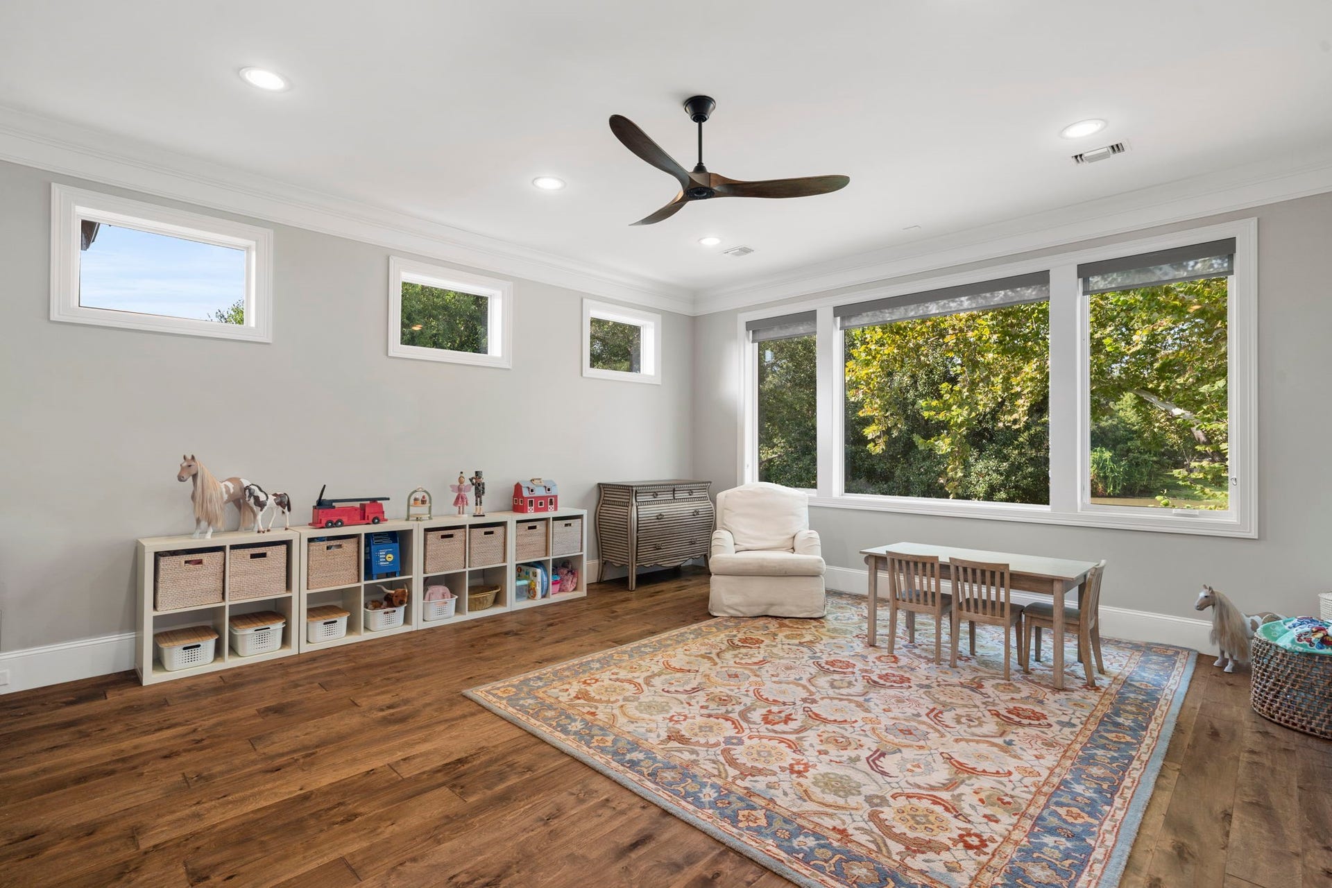 706 Oyster Creek Drive, Sugar Land, TX 77478 Clerestory windows fill the game room with natural light, complemented by elegant crown molding, recessed LED lighting, and a striking wood propeller ceiling fan for a bright, inviting space with plenty of character.