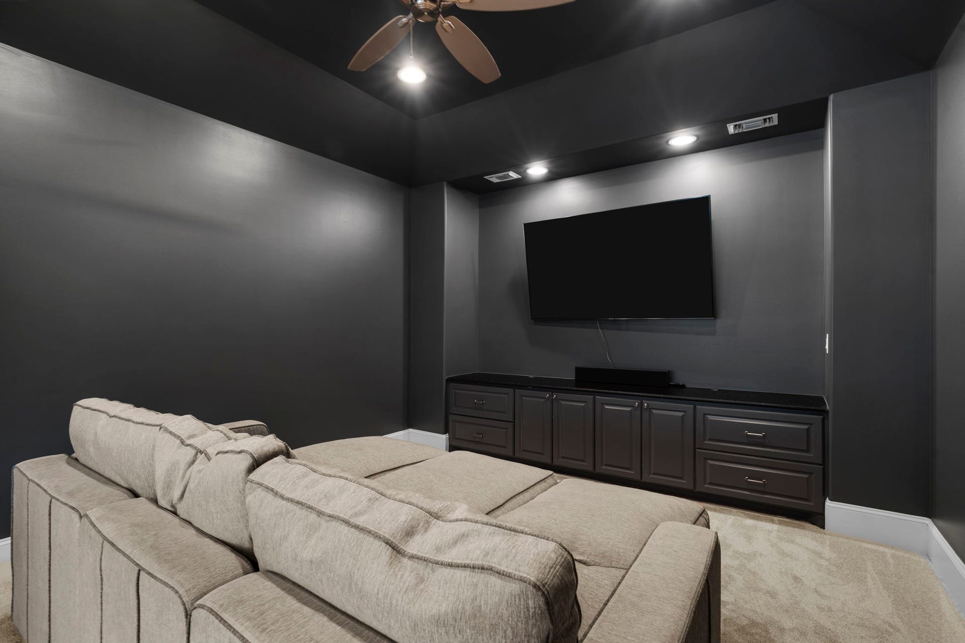 706 Oyster Creek Drive, Sugar Land, TX 77478 The Media Room is designed for comfortable movie nights and entertaining, featuring surround sound, custom built-in cabinetry, a mounted TV, recessed lighting, a ceiling fan, and brand-new carpeting installed in September 2026.