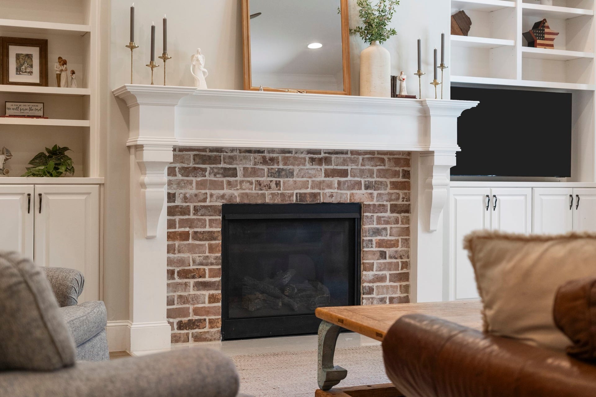 706 Oyster Creek Drive, Sugar Land, TX 77478 A classic brick fireplace anchors the living room, featuring a timeless wood mantel, gas logs with convenient remote start, and brickwork that echoes the homes exterior, creating a cohesive connection between the interior and exterior.