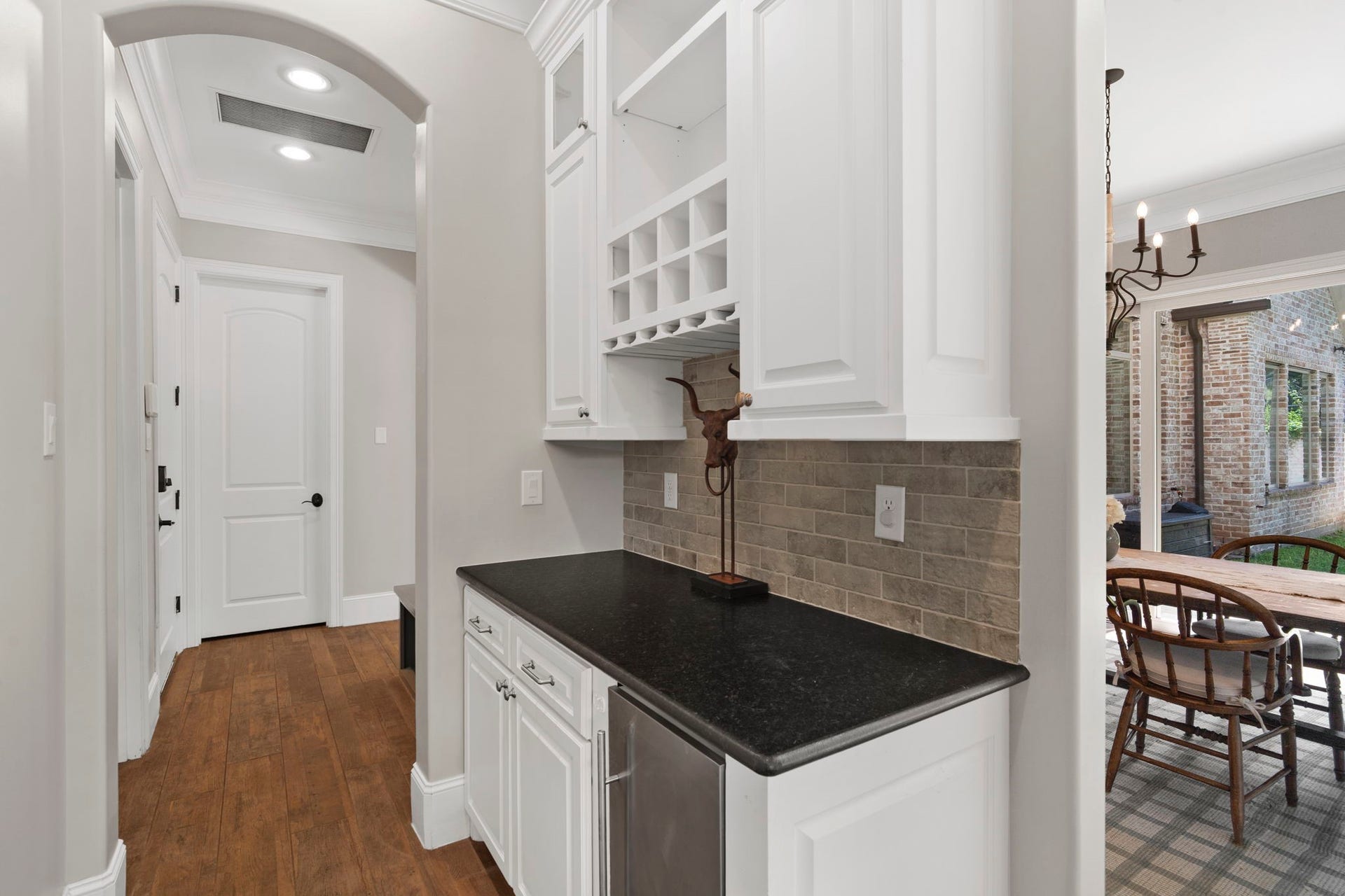 706 Oyster Creek Drive, Sugar Land, TX 77478 A dry bar is ideally located adjacent to the dining room and kitchen, featuring a mini fridge, custom built-in cabinetry, a wine rack, and counter space. Plumbing is already in place should you choose to add a sink.