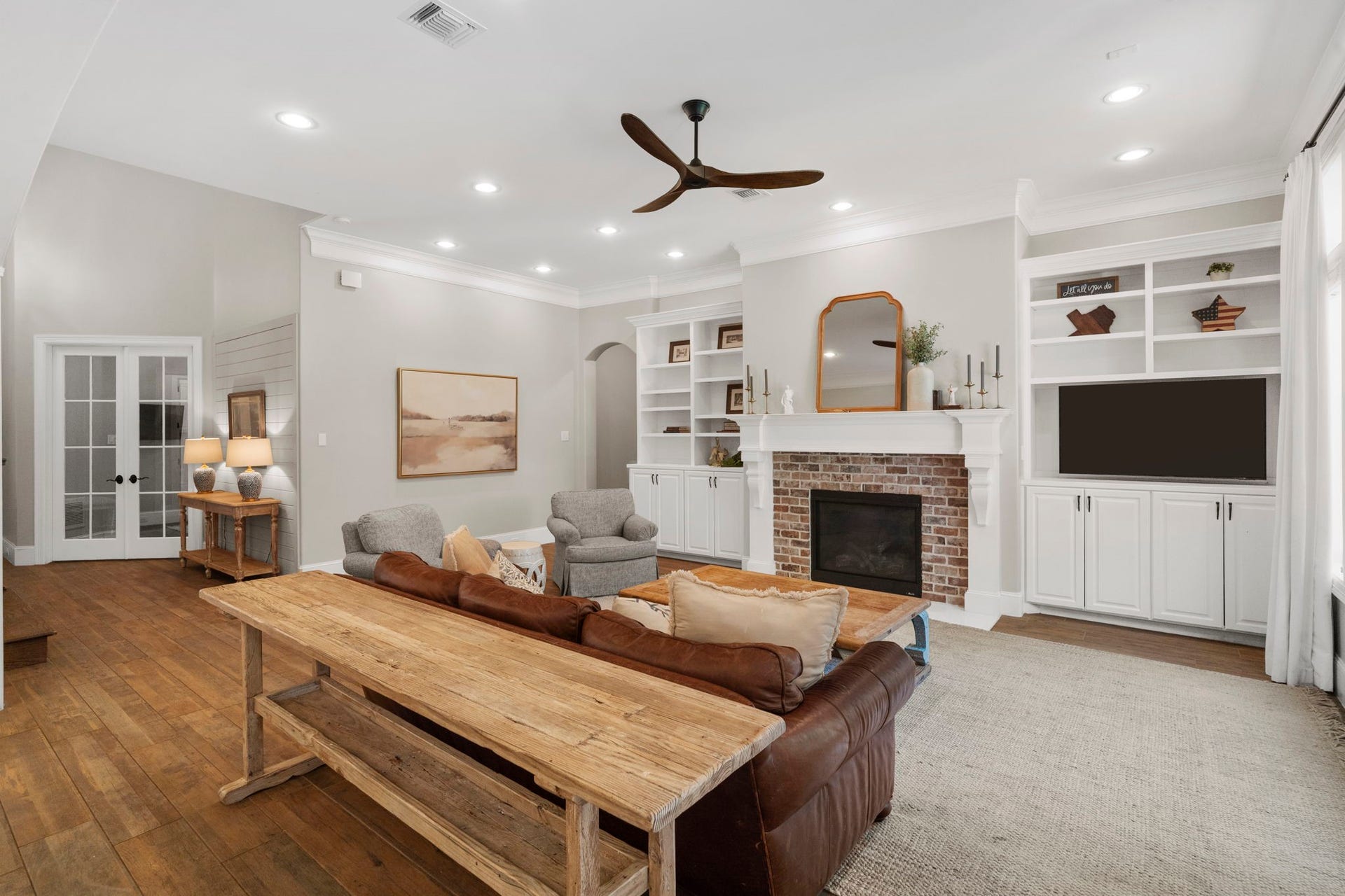 706 Oyster Creek Drive, Sugar Land, TX 77478 A charming brick fireplace serves as the focal point of the living room, complemented by beautifully crafted custom built-in cabinetry that adds character and storage.