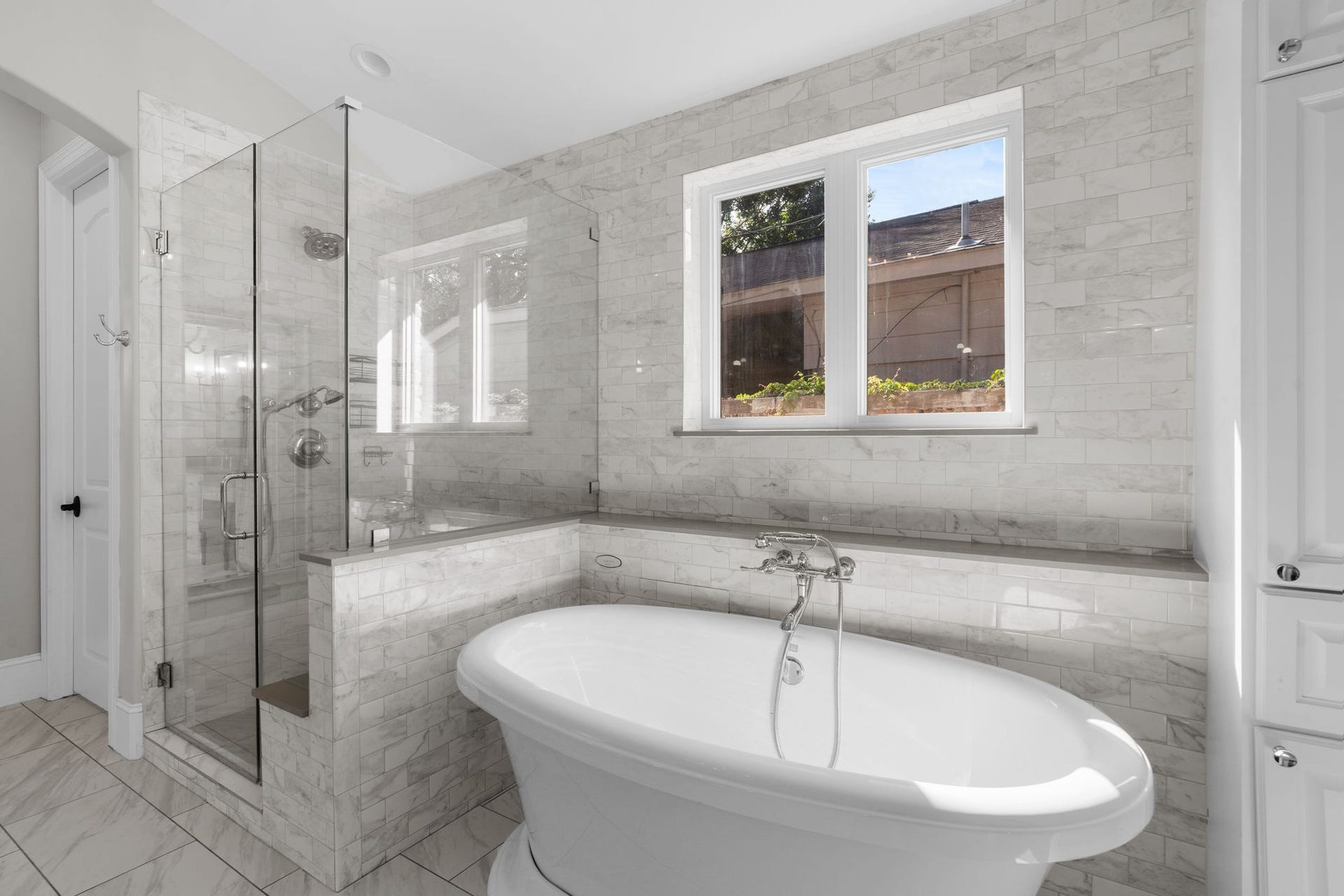 706 Oyster Creek Drive, Sugar Land, TX 77478 Relax in the freestanding soaking tub with jets and a handheld shower, or enjoy the glass-enclosed walk-in shower with a built-in seat for a comfortable, spa-like experience.