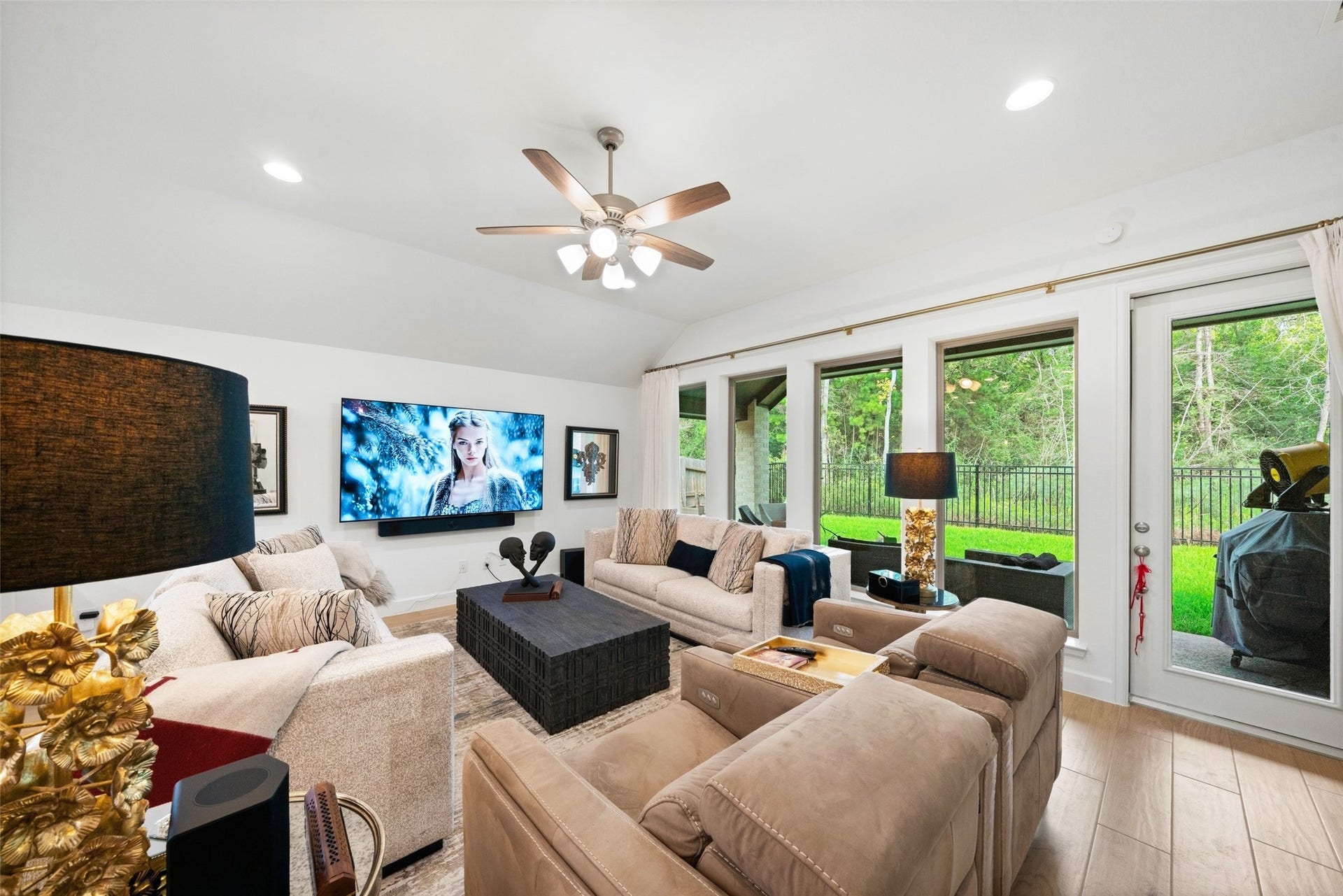 118 Sierra Stream Court, Conroe, TX 77304 Inviting family room features generous seating space, elevated ceilings, and a beautiful wall of windows overlooking the private backyard and wooded greenbelt. The open layout provides an effortless connection to the kitchen and dining areas.