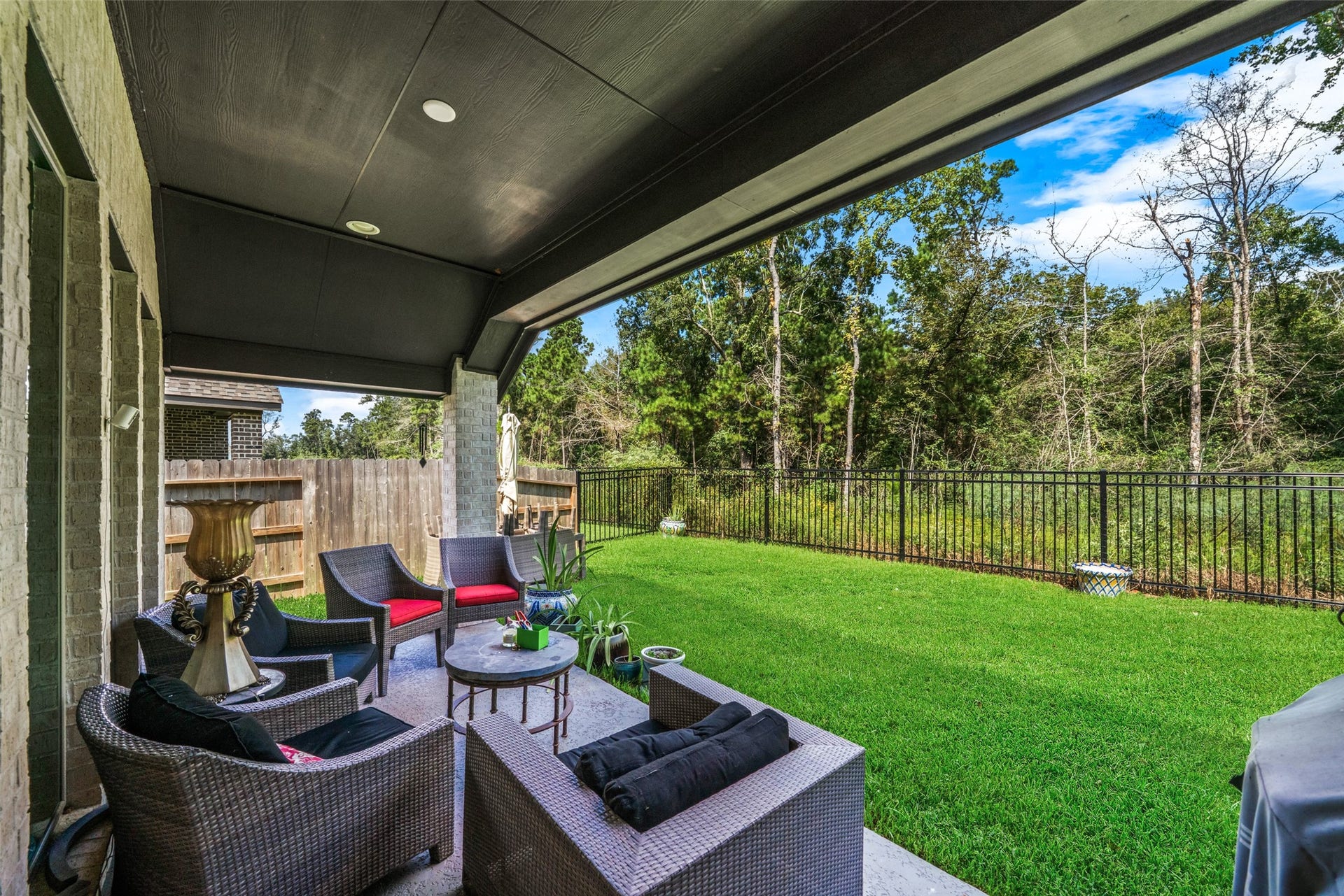 118 Sierra Stream Court, Conroe, TX 77304 Inviting covered patio overlooks a beautifully maintained backyard bordered by a lush, wooded greenbelt. With no rear neighbors, this peaceful outdoor setting offers exceptional privacy and an ideal space for relaxing or entertaining.