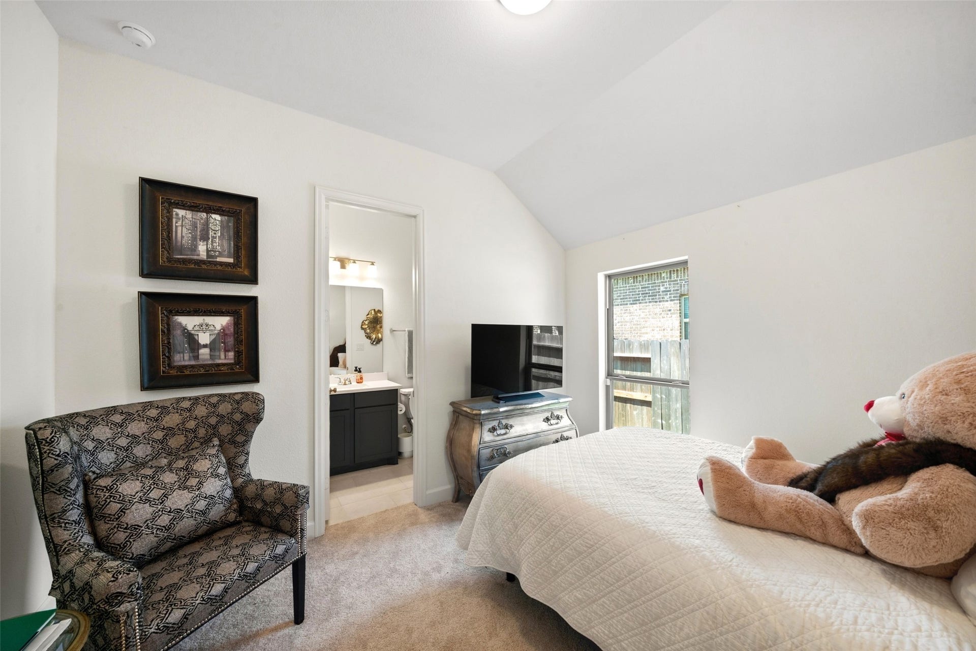 118 Sierra Stream Court, Conroe, TX 77304 Inviting secondary bedroom features elevated ceilings, soft neutral finishes, and natural light. Convenient access to a private full bathroom enhances comfort and functionality.