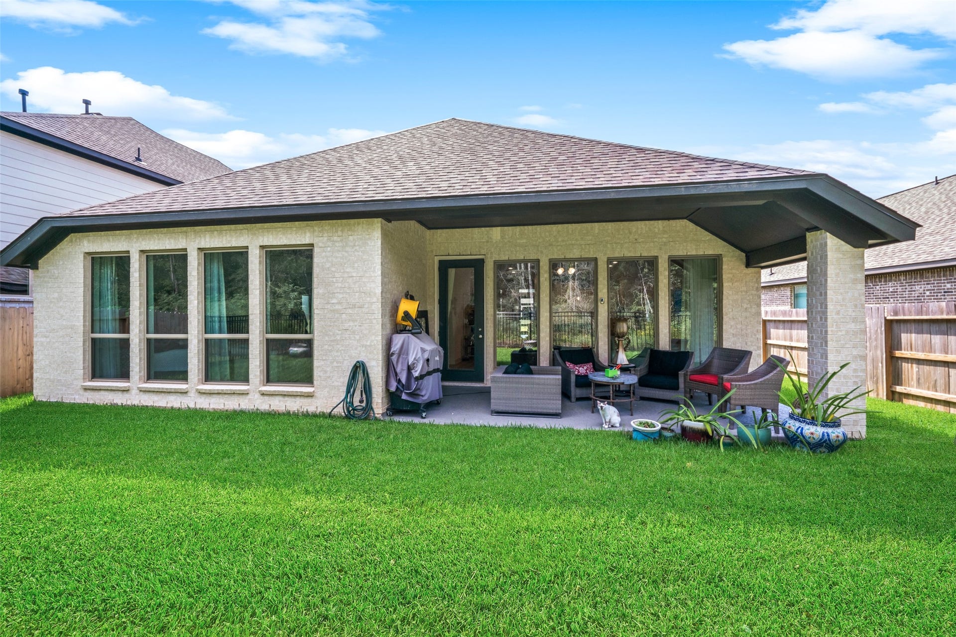 118 Sierra Stream Court, Conroe, TX 77304 Spacious covered patio provides an inviting extension of the home's living areas, with ample room for comfortable outdoor seating and entertaining. Large windows overlooking the backyard bring natural light indoors and enhance the connection between interior and exterior spaces.