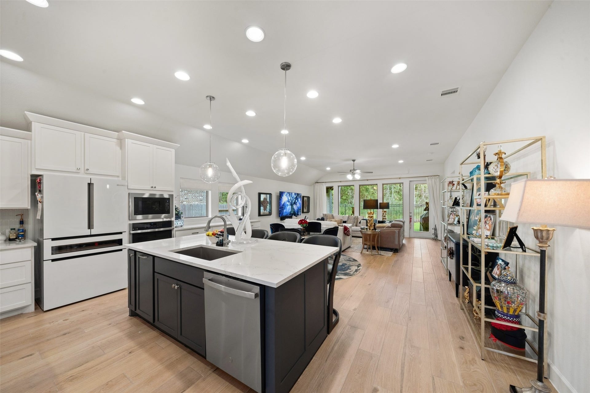 118 Sierra Stream Court, Conroe, TX 77304 Expansive open-concept design seamlessly connects the kitchen, dining, and family room, creating an exceptional setting for everyday living and entertaining. A striking oversized island, abundant cabinetry, and expansive rear windows elevate the space.