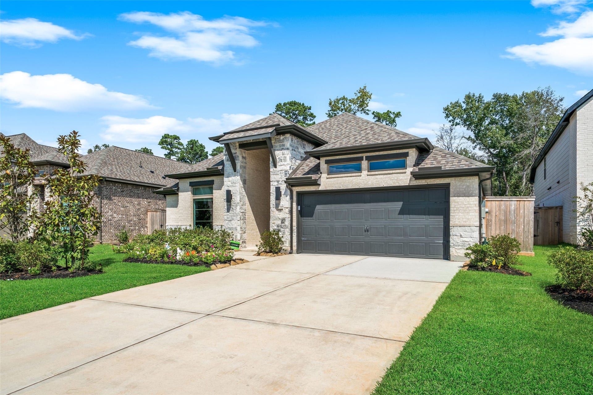 118 Sierra Stream Court, Conroe, TX 77304 Beautifully maintained home featuring a striking combination of stone and brick, contemporary architectural details, and manicured landscaping. An inviting covered entry and two-car garage enhance the home's curb appeal.