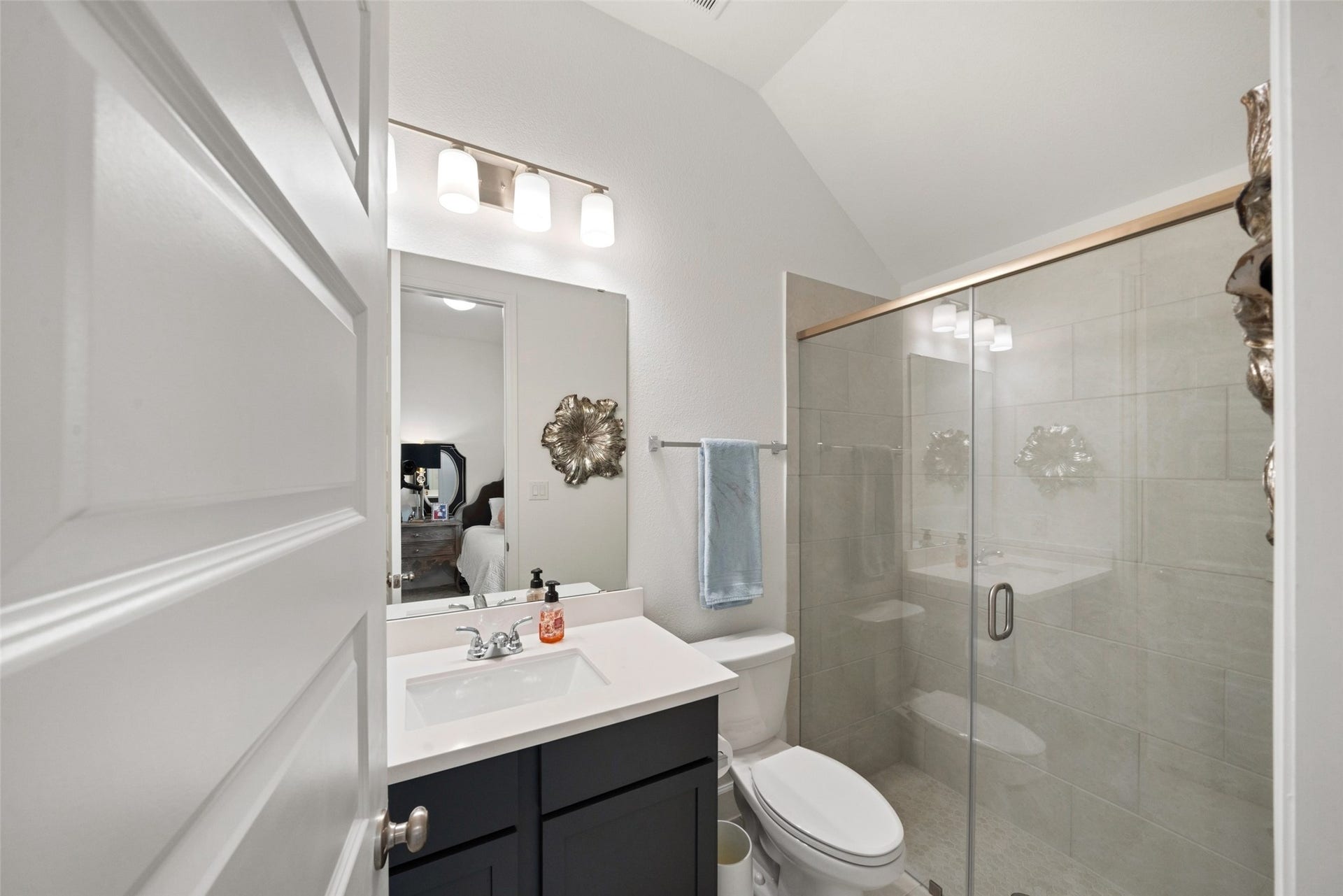 118 Sierra Stream Court, Conroe, TX 77304 Beautifully finished en-suite bathroom featuring dark cabinetry, a crisp white countertop, and a spacious glass-enclosed shower with contemporary tilework. Neutral finishes and modern fixtures create a polished, timeless aesthetic.