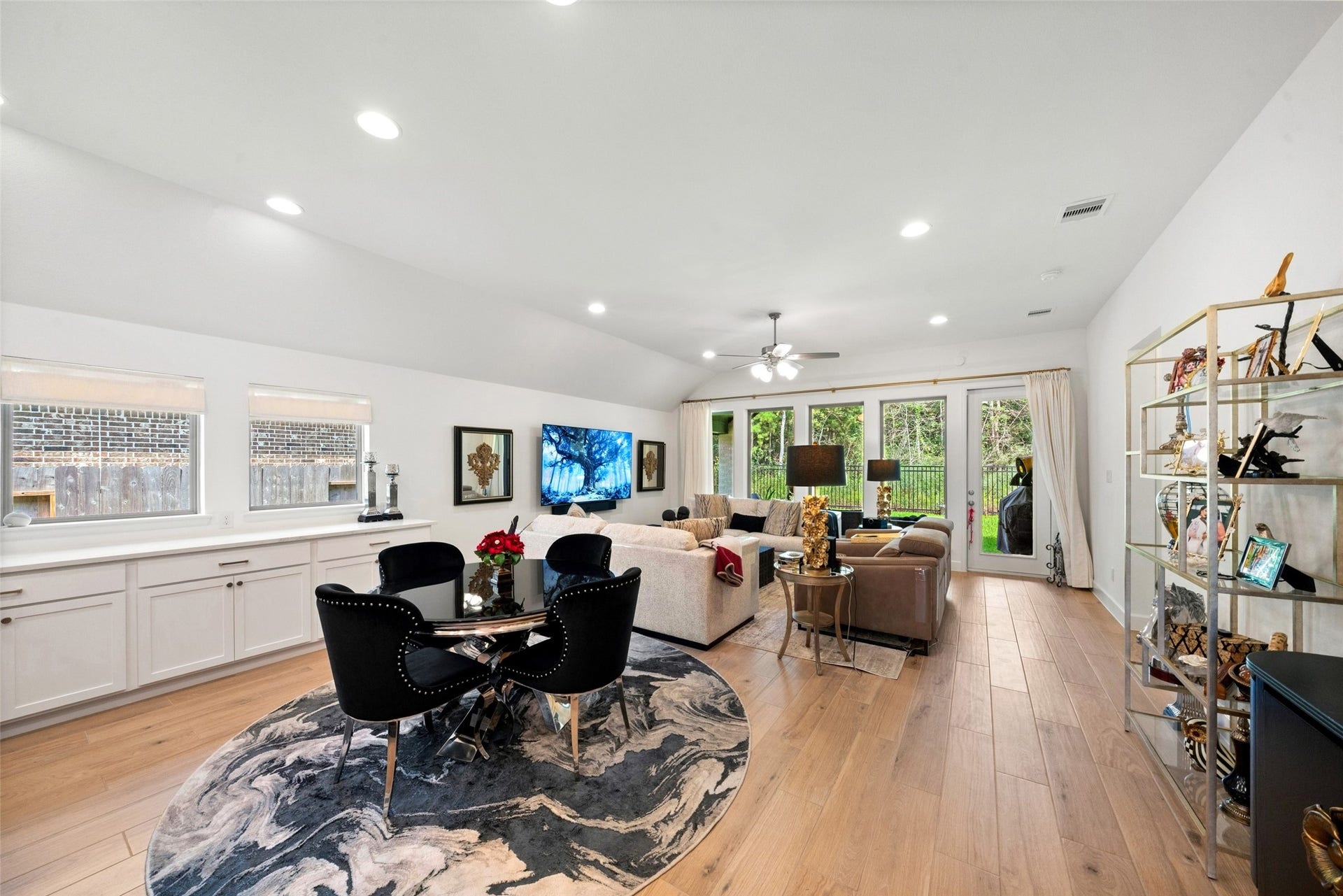 118 Sierra Stream Court, Conroe, TX 77304 Light-filled dining and living areas offer a seamless blend of comfort and sophistication, complemented by beautiful wood-look flooring and elevated ceilings. Expansive windows frame peaceful views of the lush greenbelt beyond.