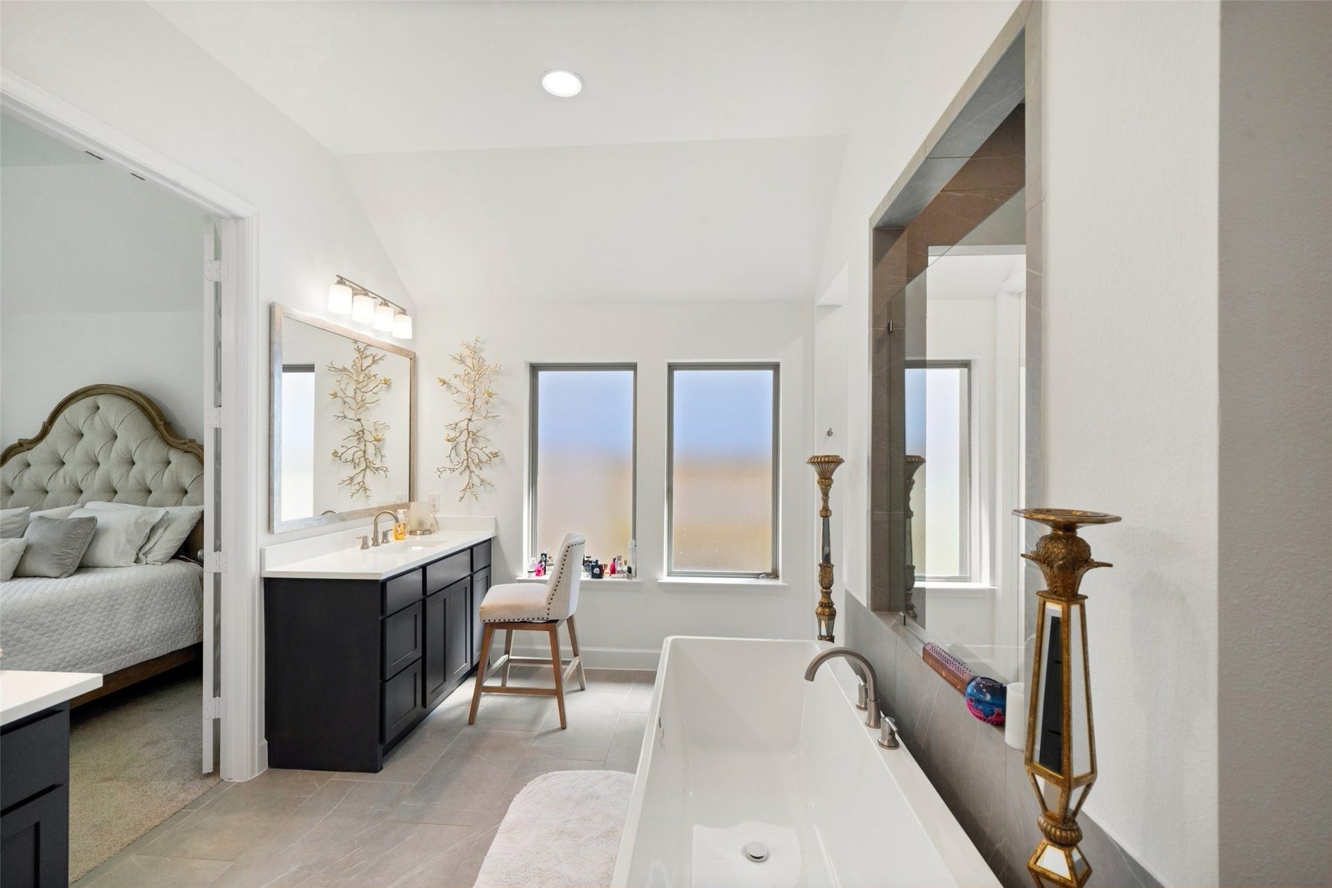 118 Sierra Stream Court, Conroe, TX 77304 Spa-inspired primary bath featuring a freestanding soaking tub, sleek dark cabinetry, elegant countertops, and an oversized glass-enclosed shower. A dedicated vanity area and natural light enhance the luxurious atmosphere.