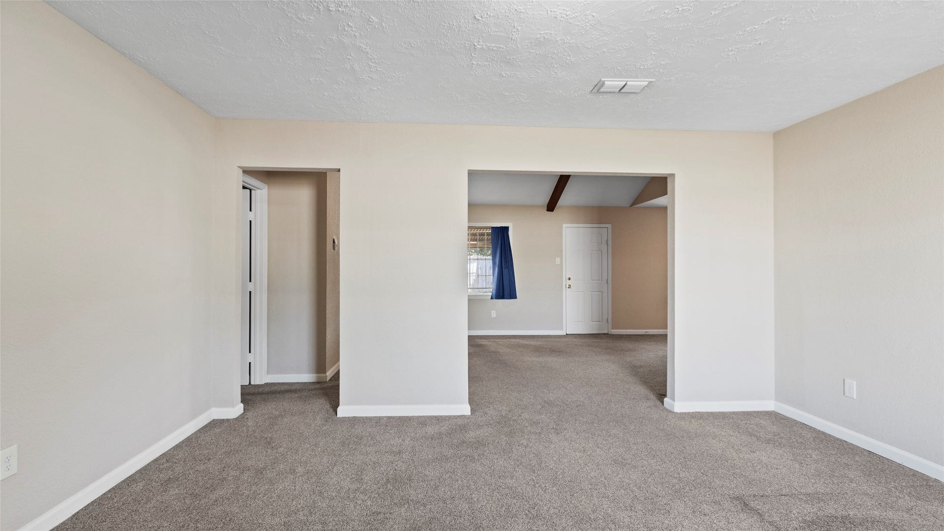 Front living area with a wide opening into the adjoining family room.