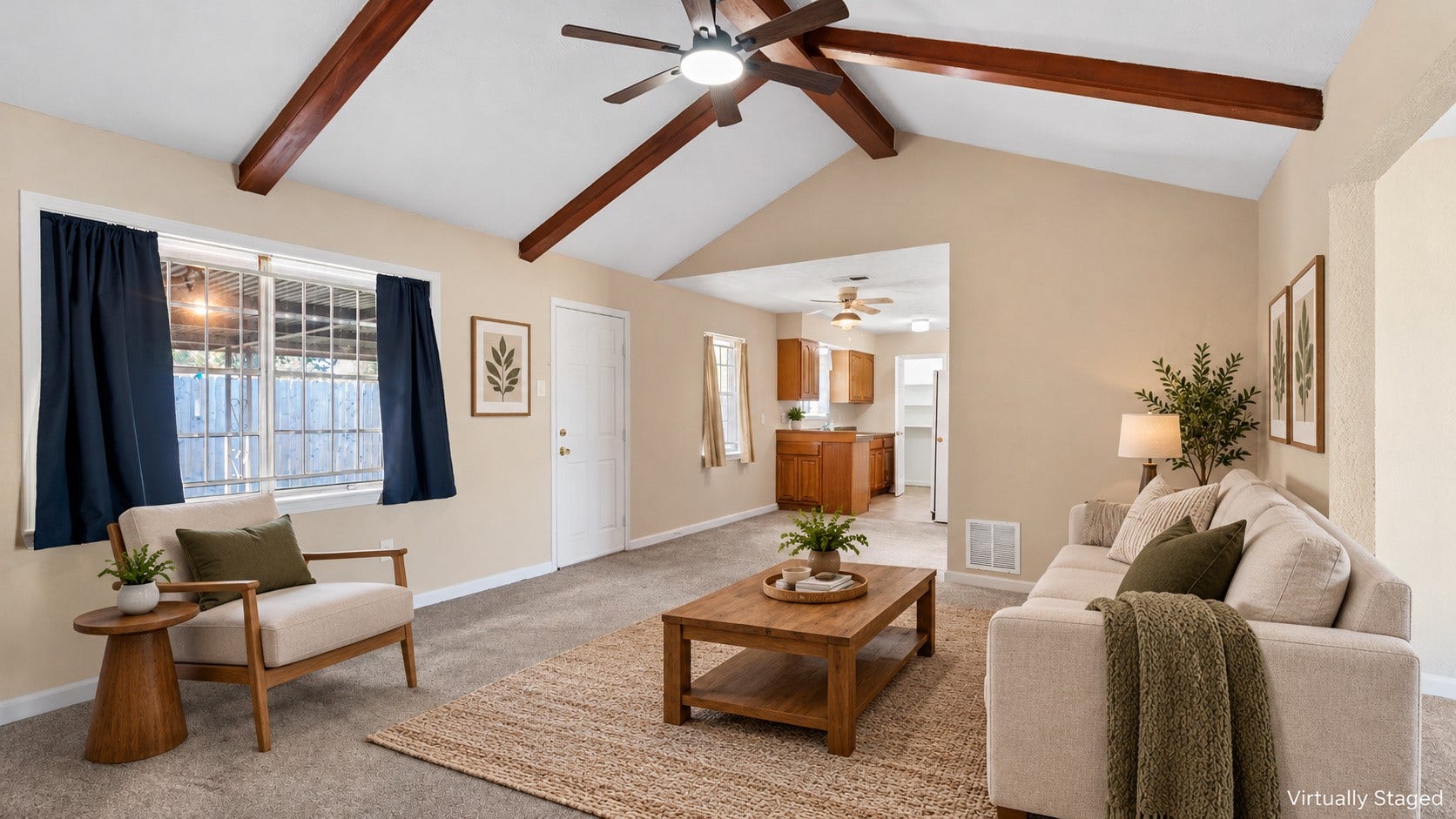 Virtually staged family room featuring vaulted ceilings, exposed beams, and patio access.