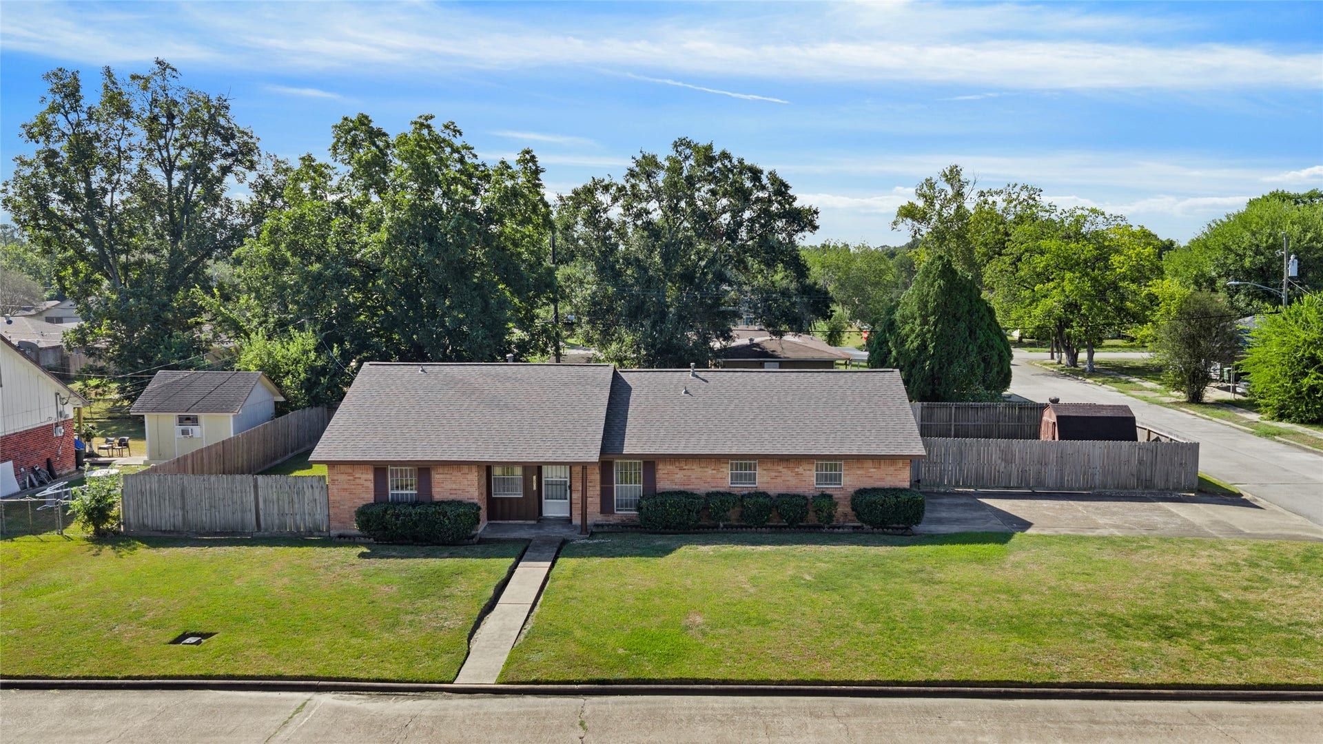 Elevated front view showcasing the brick exterior and large corner lot.