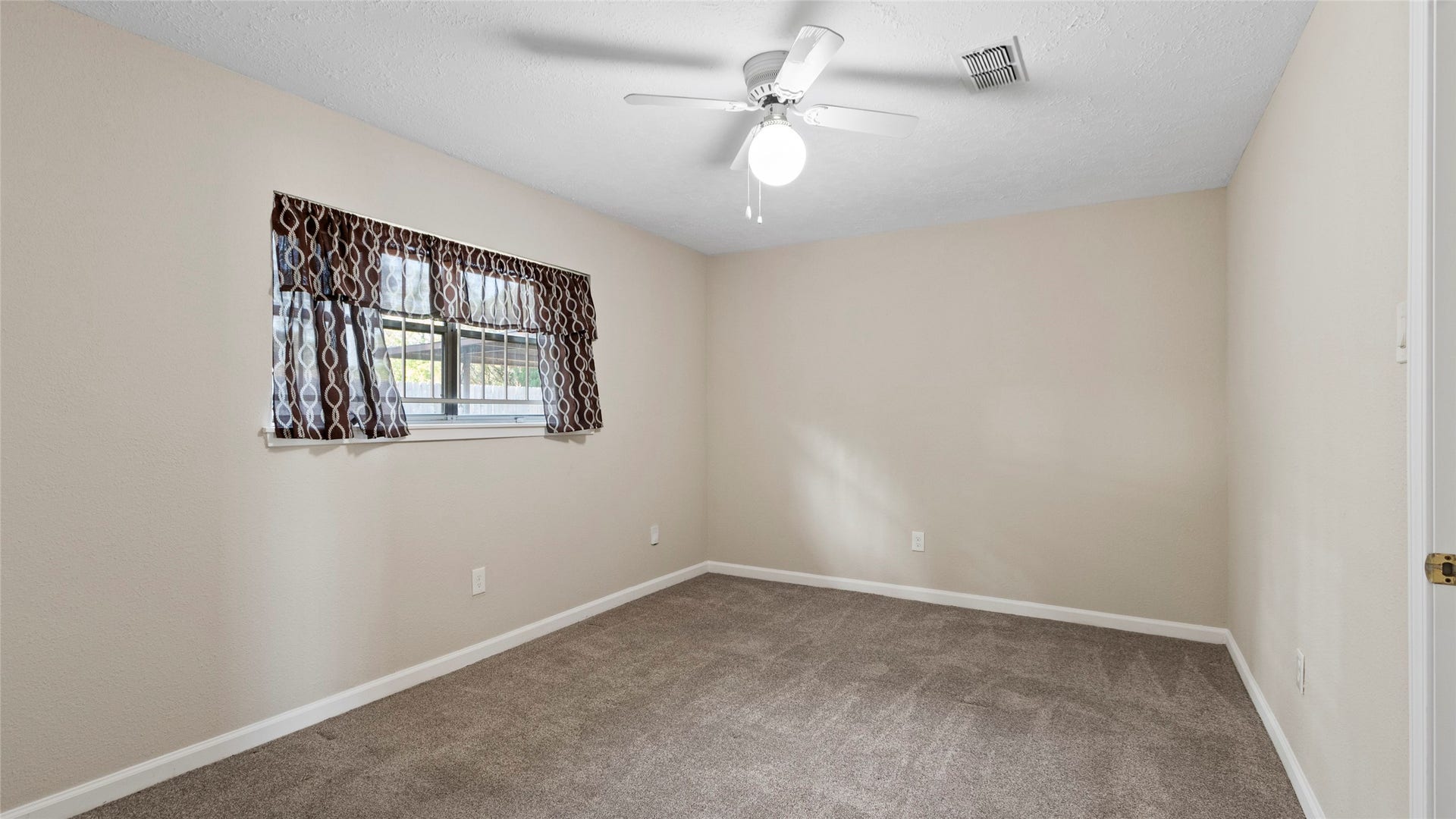 Another view of the bedrooms neutral colors and natural light.