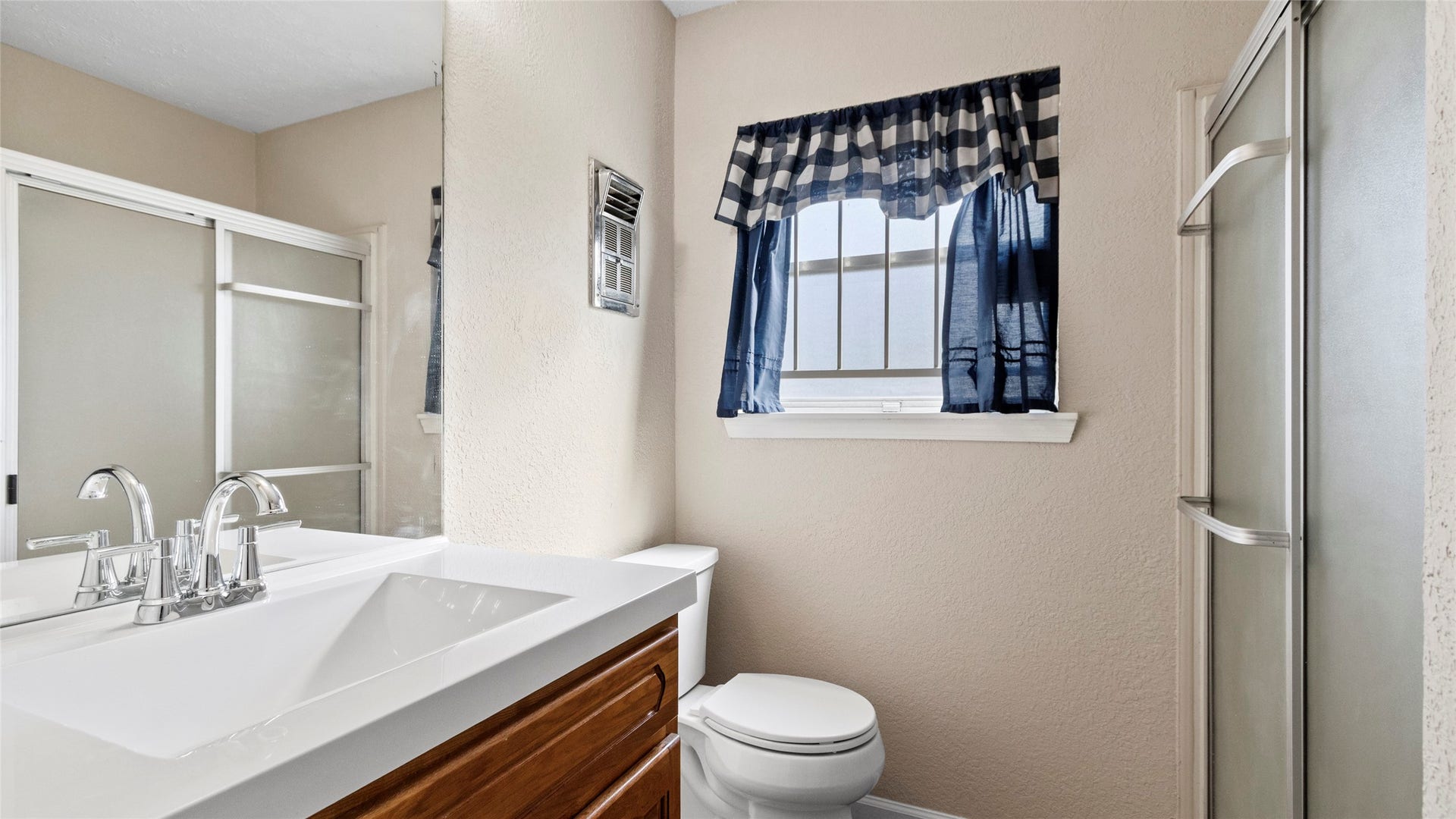 Updated bathroom featuring a white vanity top and enclosed shower.