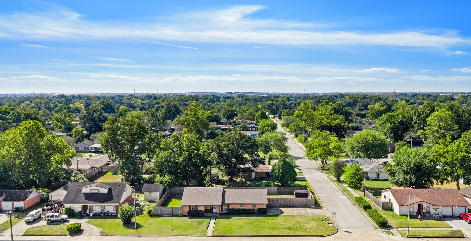 Aerial view of the corner-lot home and surrounding tree-lined neighborhood.