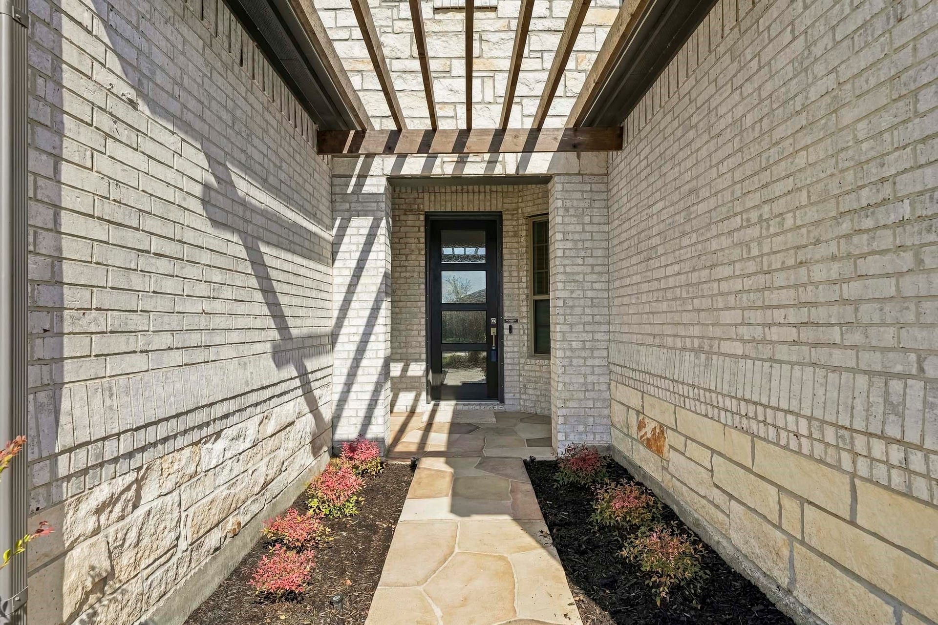 9527 Waxwing Trace, Manvel, TX 77578 Front walkway lined with landscaping and 8' front door with glass panels.