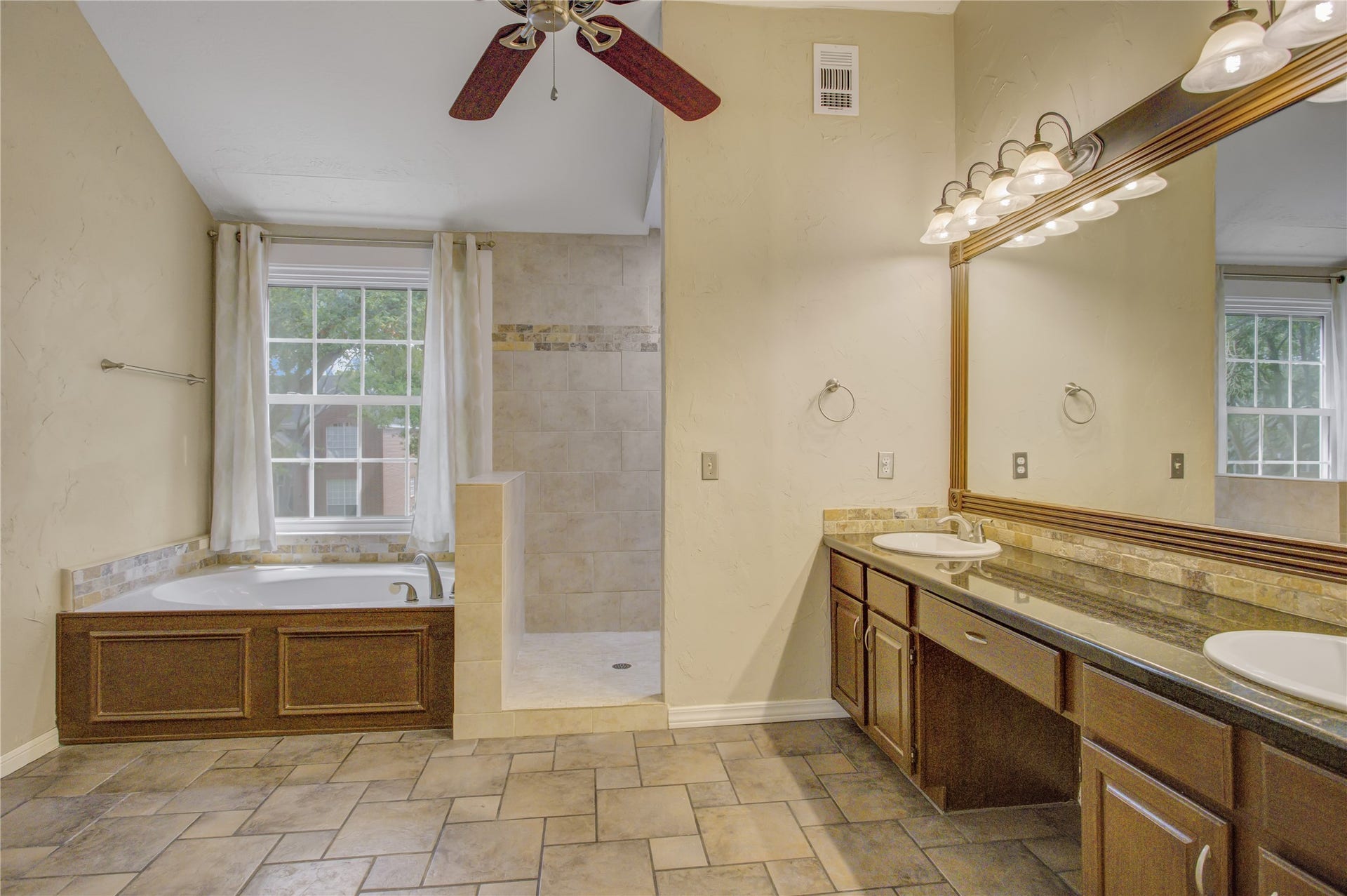 2826 Spring Lakes, Missouri City, TX 77459 Unwind in the soaking tub beneath the window, then step into the open walk-in shower.