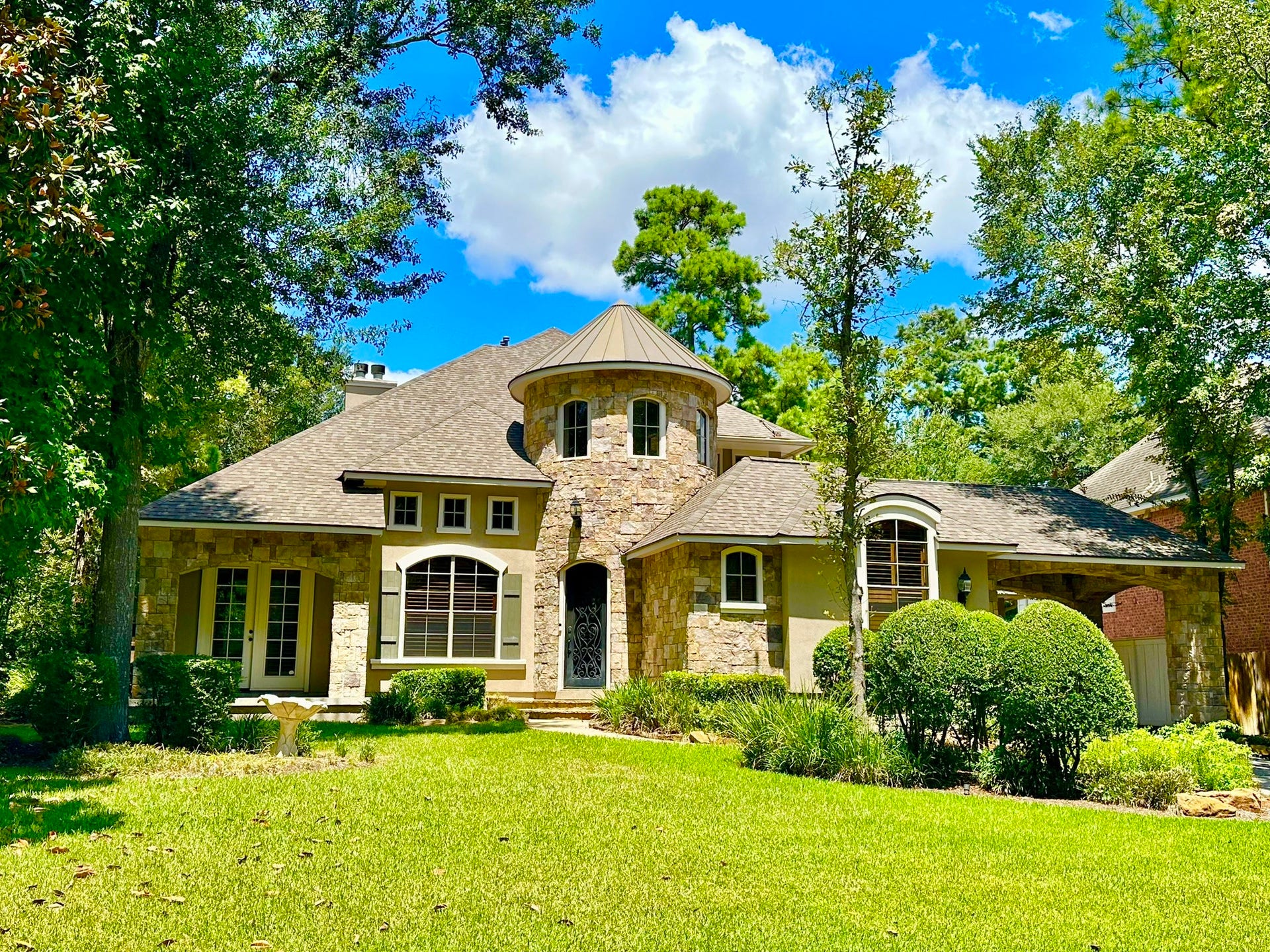 Charming stone-stucco home with a unique turret design, nestled among mature trees and lush landscaping, come make this one yours!