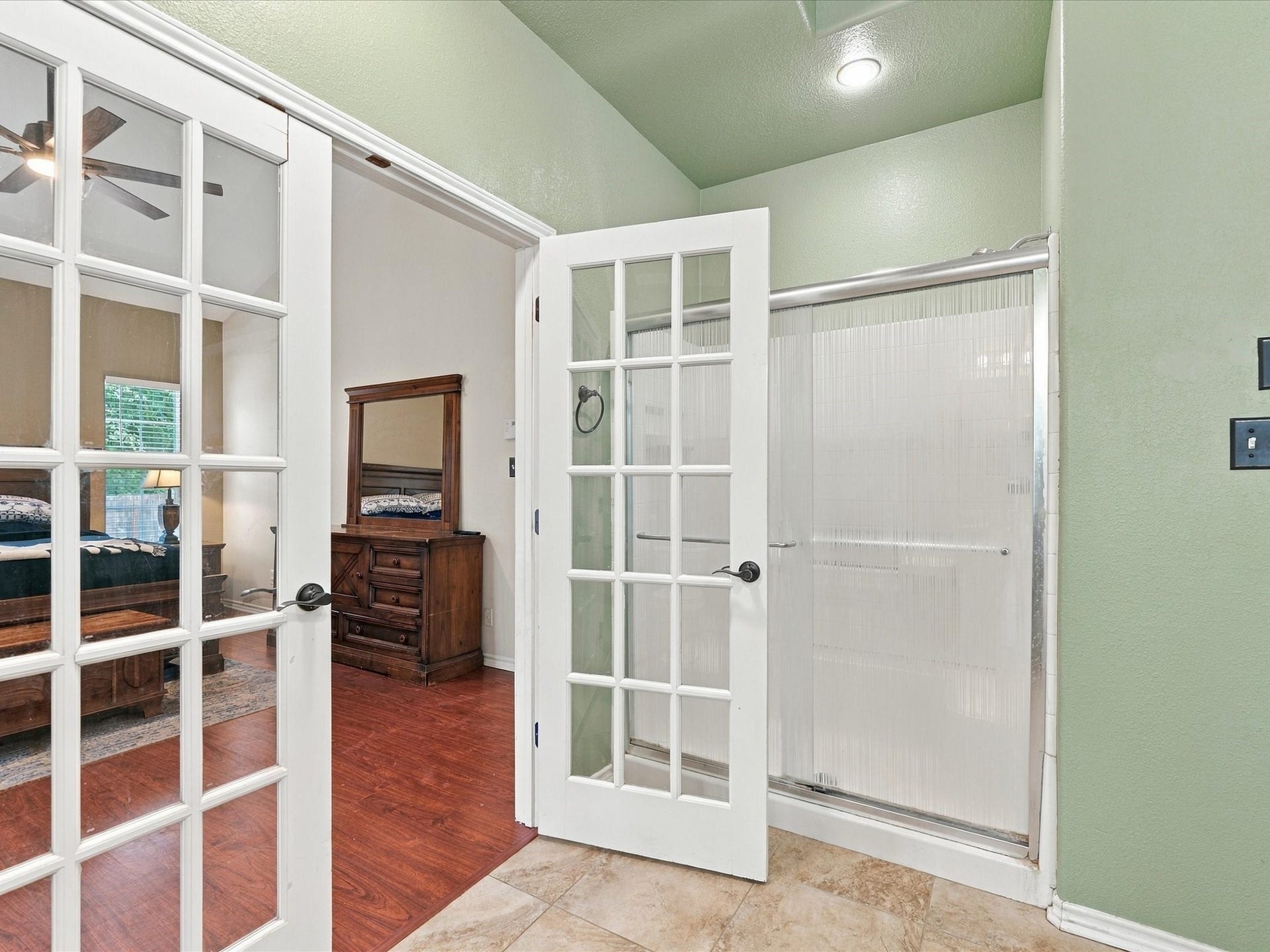 306 Sherwood Forest Street, Conroe, TX 77316 French doors connect the primary bedroom to the ensuite, which features a large walk-in shower.