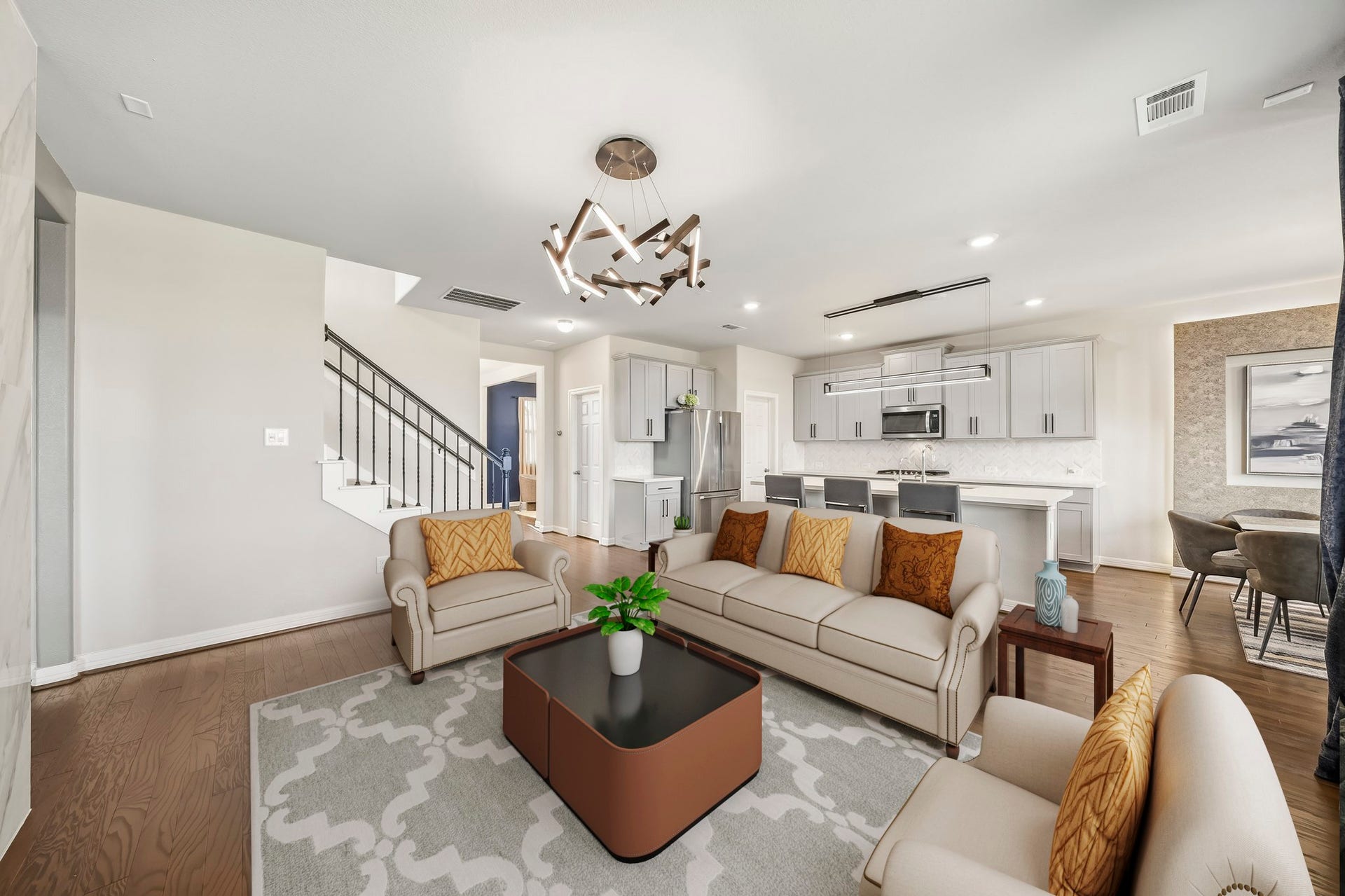 Virtually Staged: This spacious living room offers a bright, inviting setting with warm wood flooring, recessed lighting, and a contemporary statement light fixture. The generous layout provides ample room for multiple seating arrangements, making it ideal for both relaxing and entertaining.