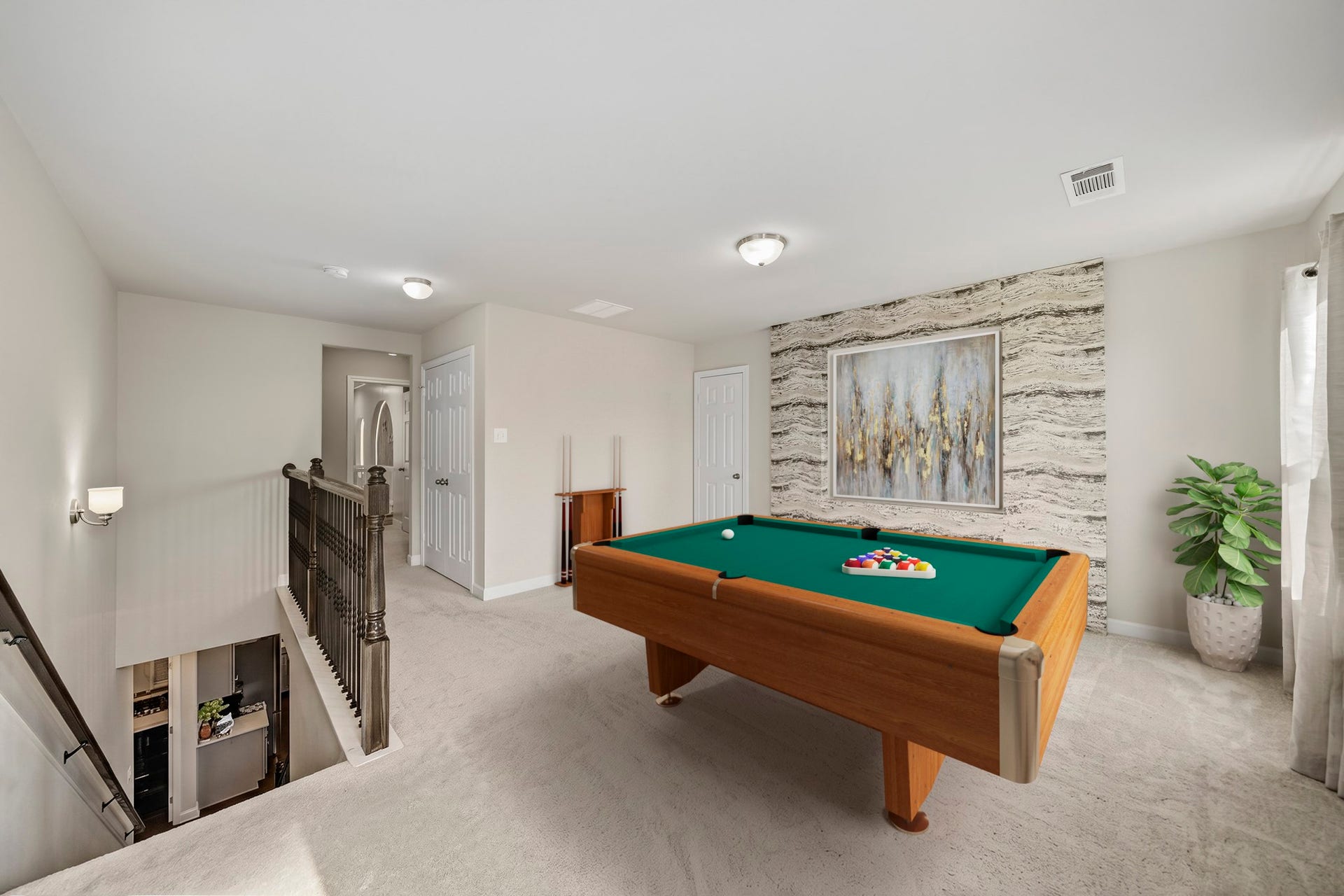 Virtually Staged: This flexible space is perfect for family fun, entertaining guests, or creating a dedicated media and recreation area. This spacious upstairs game room offers a versatile retreat designed for entertainment and relaxation. Plush carpeting, abundant natural light, and a striking accent wall create an inviting atmosphere, while the open layout provides plenty of room for a pool table, gaming area, or additional lounge seating.