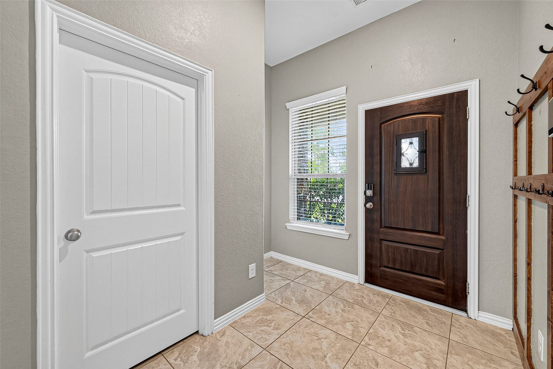 23010 Tindarey Falls Lane, Katy, TX 77493 Front Entry, Left door is washer/dryer room. small hall left of window leads to guest bath.