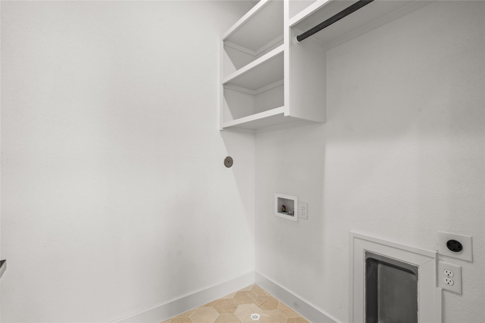 3012 & 3014 Beulah St, Houston, TX 77004 The dedicated laundry room features custom white cabinets, built-in shelving, and a hanging drying rod. The utility wall includes washer and dryer hookups with heavy-duty outlets, all set against an easy-to-clean, geometric tile floor.