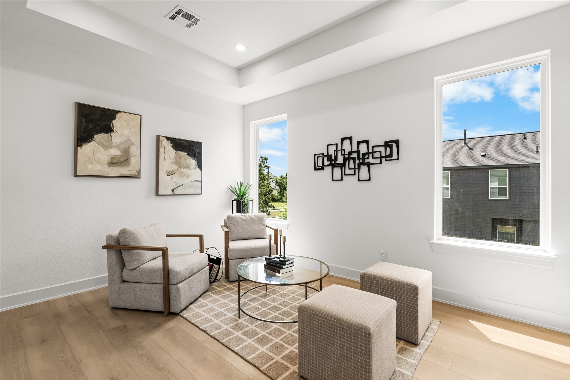 3012 & 3014 Beulah St, Houston, TX 77004 This view shows the size and natural light of the upper lounge. Large windows look out over the neighborhood and keep the room bright, while the open layout easily fits multiple chairs, accent cubes, and a coffee table.