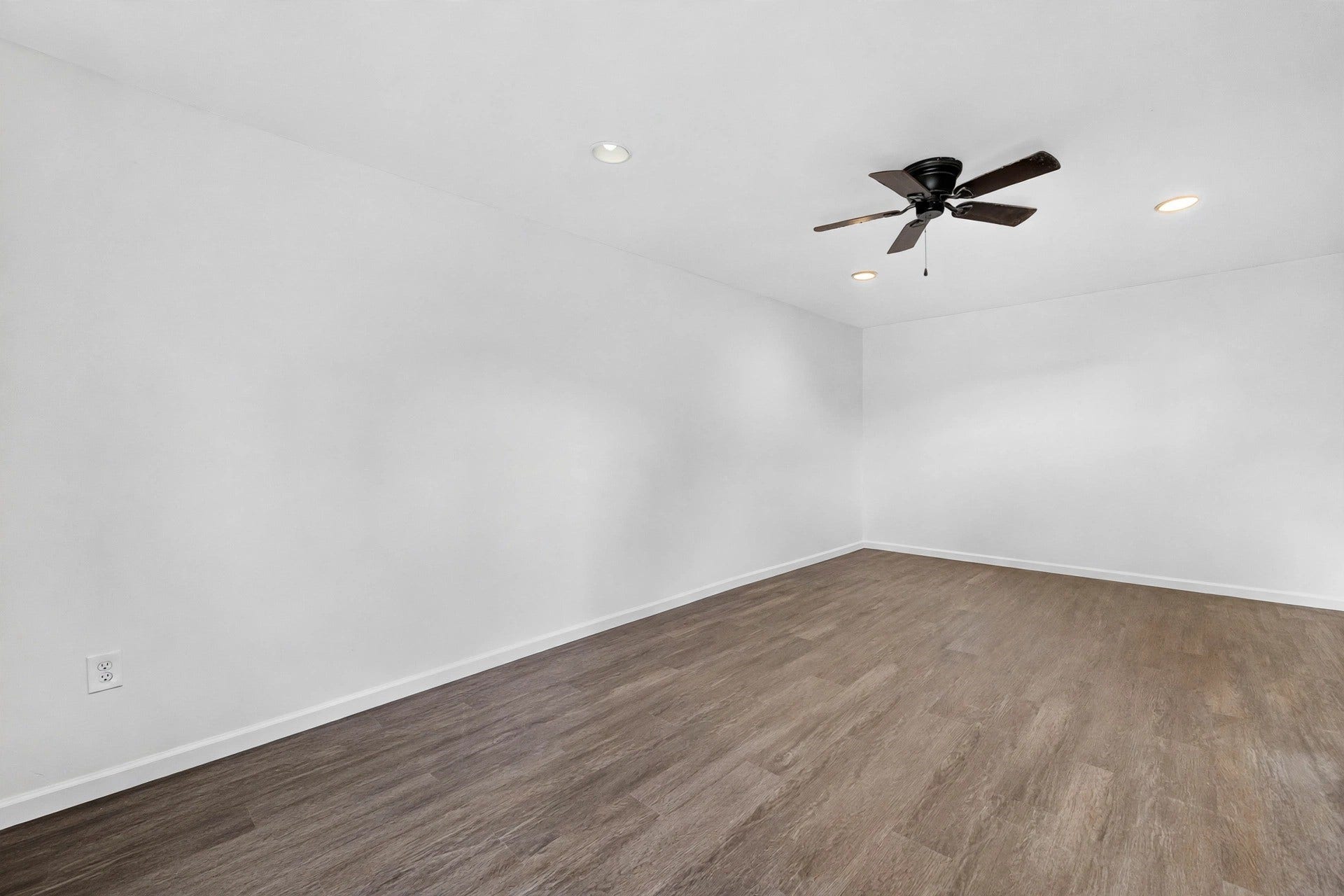 1123 Woodhorn Drive, Houston, TX 77062 Flexible interior room with walls, wood-look flooring, a dark ceiling fan, and recessed lighting.