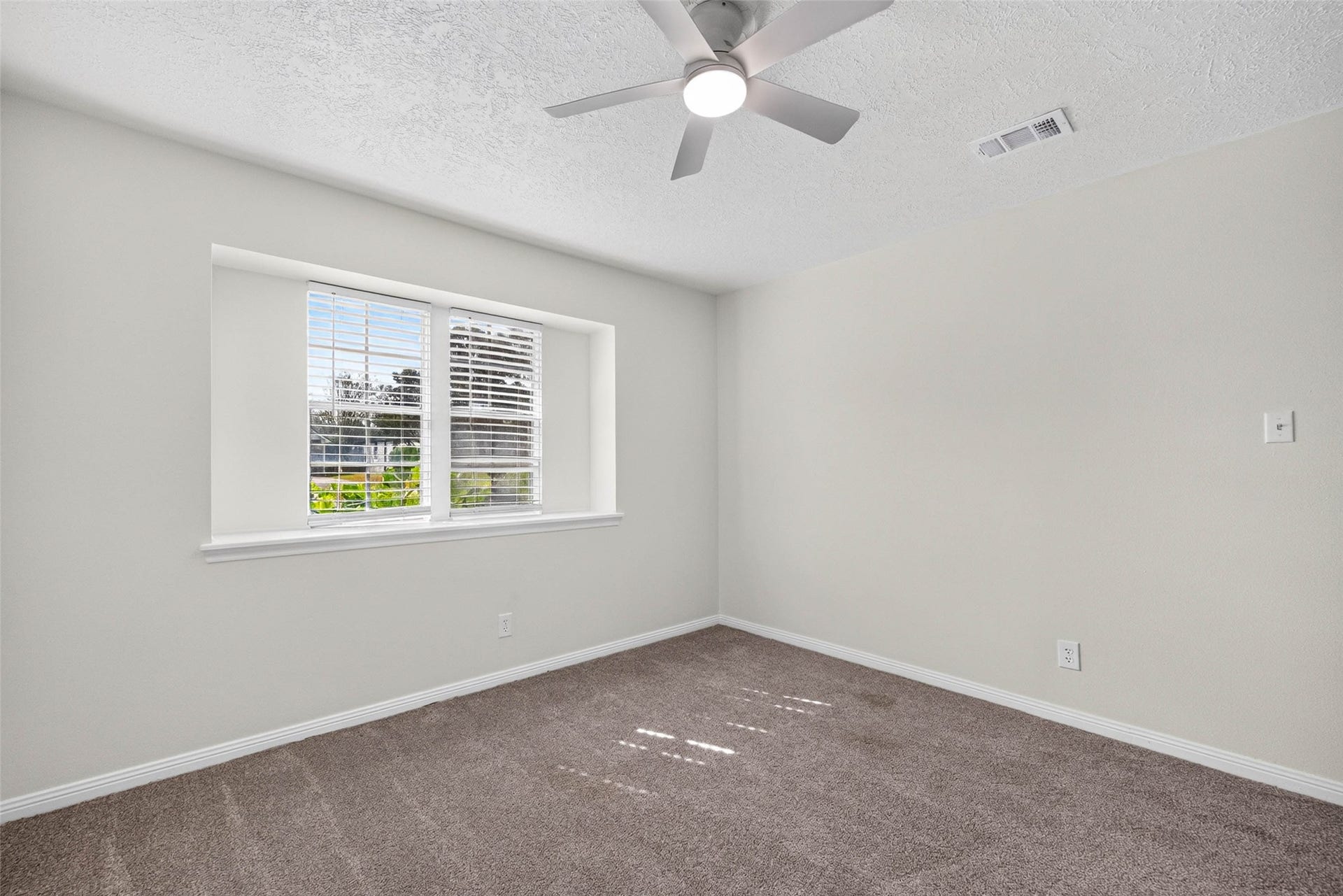 1123 Woodhorn Drive, Houston, TX 77062 Another angle of the carpeted bedroom, with the same recessed double windows, ceiling fan, and soft neutral walls.