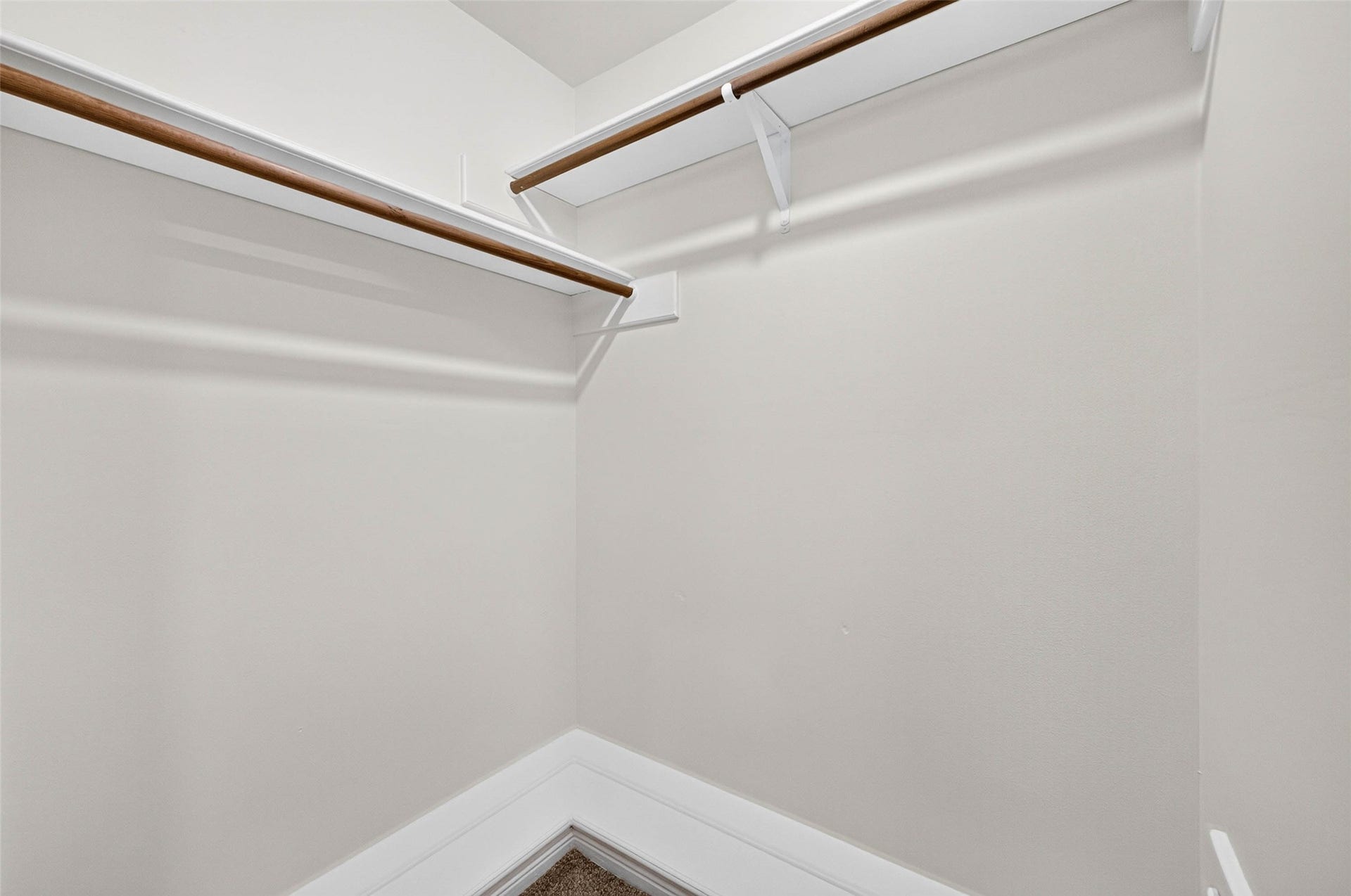 1123 Woodhorn Drive, Houston, TX 77062 Walk-in closet with wood hanging rods and shelving running along two walls.