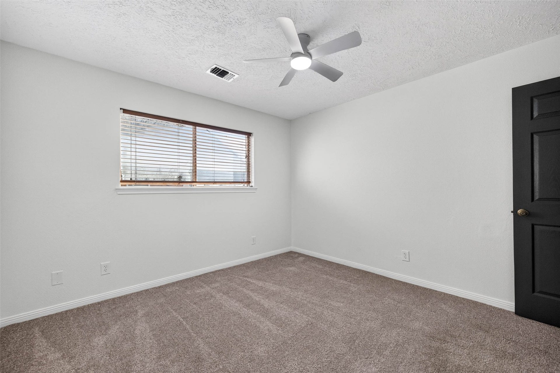 1123 Woodhorn Drive, Houston, TX 77062 Carpeted bedroom with a wide window with blinds, a ceiling fan with light, and a dark interior door.