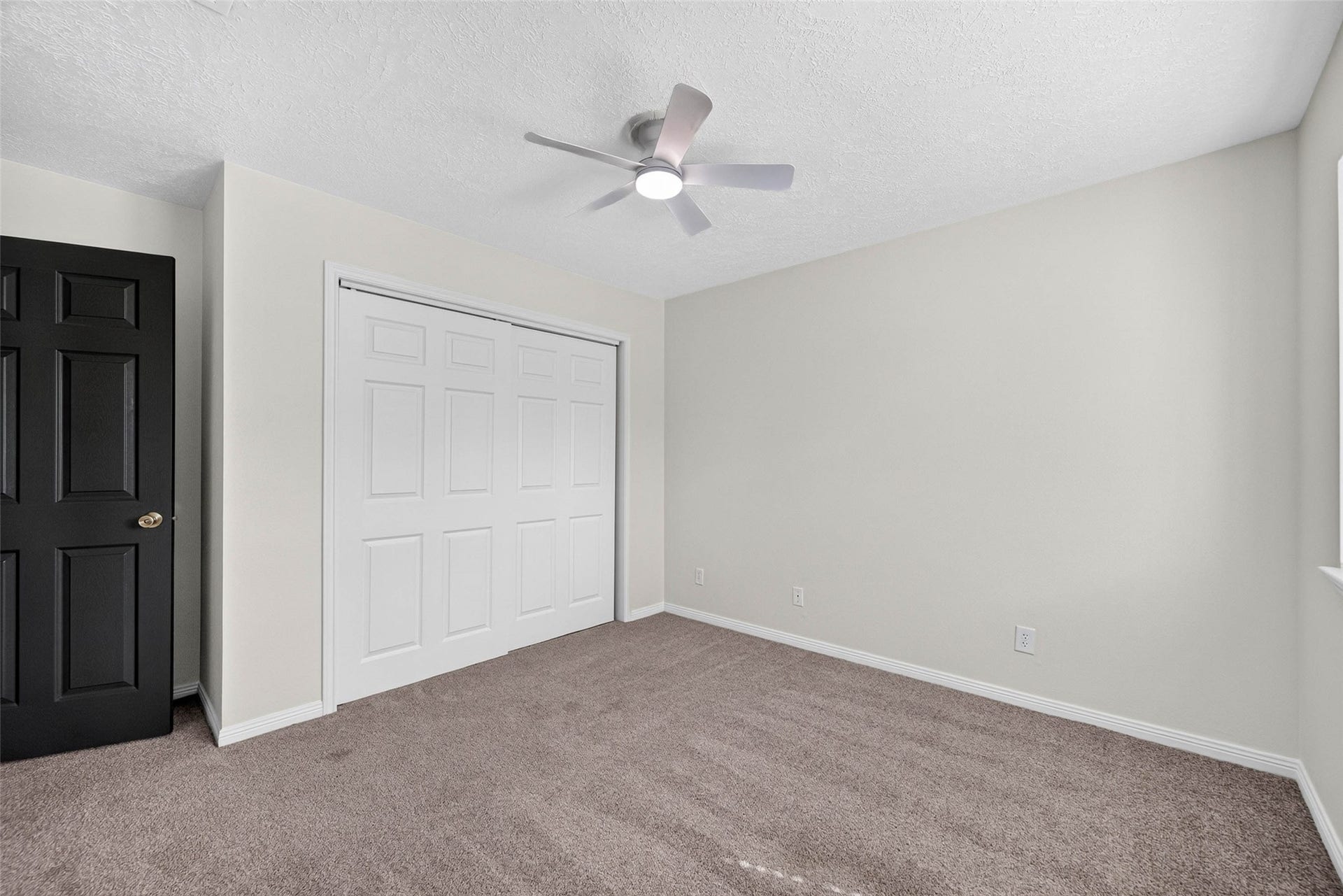 1123 Woodhorn Drive, Houston, TX 77062 Carpeted bedroom with sliding closet doors, a dark interior door, and a ceiling fan with light.