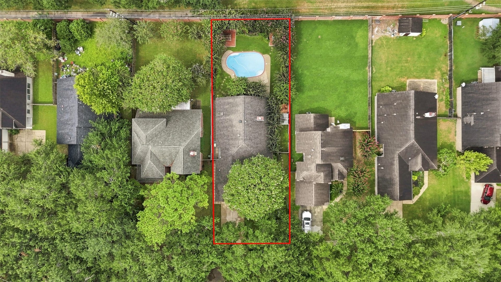 Aerial view highlights the property boundaries, mature tree coverage, private backyard, and in-ground pool.